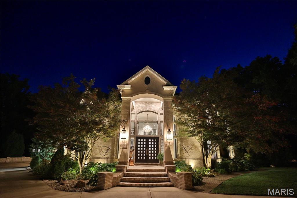 California Coastal in the Midwest: Stunning 5 bed, 8 bath, 2-story in Sunset Hills Estates, completely transformed with a sophisticated high-end rebuild in 2016 by the current owners. A custom mahogany front door opens to a grand foyer with oxidized tiles, curved staircase, and RH crystal/metal chandelier. The living area is anchored by a soaring 20’ vintage Douglas Fir timber. Chef’s kitchen boasts Danby marble countertops and island with Subzero, Wolf, and Miele appliances.
The main-level primary suite is entered through twin 8’ antique doors, with leather plank flooring and a large-scale gas fireplace. Spa-inspired bath offers a freestanding soaking tub, Italian mosaic steam shower, and a must be seen boudoir. The upper level includes: 3 ensuite bedrooms with walk-ins, an open office with built-ins, and a magazine-featured wine loft with lounge and commercial-grade, glass-walled 1000-bottle storage.
The multi-walkout lower level includes a 2-level theater, entertaining area with wet bar/kitchenette, 2 full baths, guest suite, laundry, bonus room, exercise room, & workshop. Outdoor living area features a covered Trex deck with spiral staircase to a covered epoxy patio & hot tub. Landscape lighting enhances the private backyard. Control4 smart home system manages museum-quality lighting, multi-zone music, & executive-level security in-house or remotely. Only 20+ miles to downtown STL & airport!  A must see to appreciate-so much more than with that new construction!