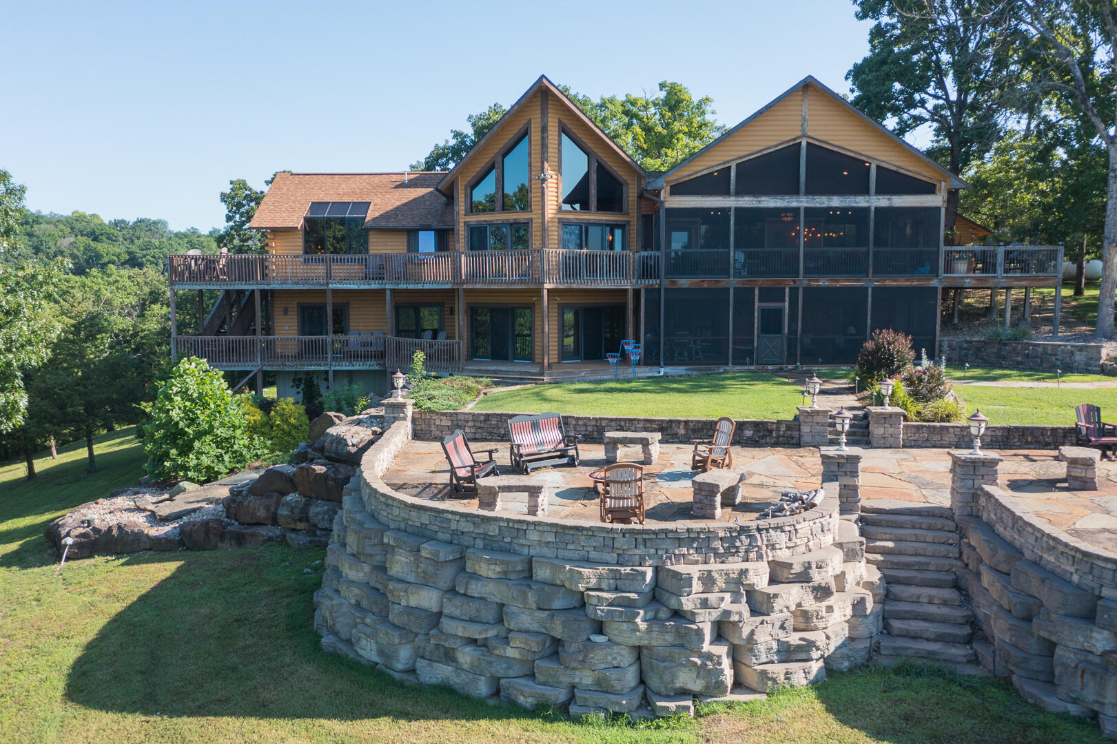 Imagine waking up every day to the serene beauty of Table Rock Lake, surrounded by 16 acres of private land. This extraordinary log cabin retreat offers the perfect blend of rustic charm, artistic design, and luxurious amenities, creating a one-of-a-kind experience for those seeking a dream vacation home or a private getaway. With 7 bedrooms, 6.5 baths, and custom-designed interiors, this cabin offers an exceptional opportunity for those in search of a truly remarkable property. Every corner of this home tells a story of expert craftsmanship and careful design. Created by an artist with a portfolio that includes renowned spaces like Bass Pro, Big Cedar Lodge, and Top of the Rock, the home is designed to capture the essence of natural beauty while offering a level of luxury that is both comfortable and captivating. The home's interiors are filled with hand-crafted furnishings designed specifically for the space, bringing together elements of rustic elegance and modern sophistication.From the custom wrought iron fixtures to the one-of-a-kind cowhide chandeliers , every detail is intentional and thoughtfully placed. The design of the home integrates seamlessly with its natural surroundings, creating an atmosphere that feels as timeless as the landscape itself. The heart of the home is its expansive living spaces, where friends and family can gather for relaxed meals, conversation, or simply to unwind. The open-concept layout makes the most of the incredible views of Table Rock Lake, with large windows that flood the home with natural light. The living room, with its soaring ceilings and stunning stone fireplace, is the perfect spot to relax after a day spent exploring the outdoors.The spacious kitchen is a chef's dream, complete with high-end appliances, ample counter space, and custom cabinetry that blends rustic and contemporary design elements. Whether preparing a family dinner or entertaining guests, this kitchen offers10x28 Boat slip  with lift available
