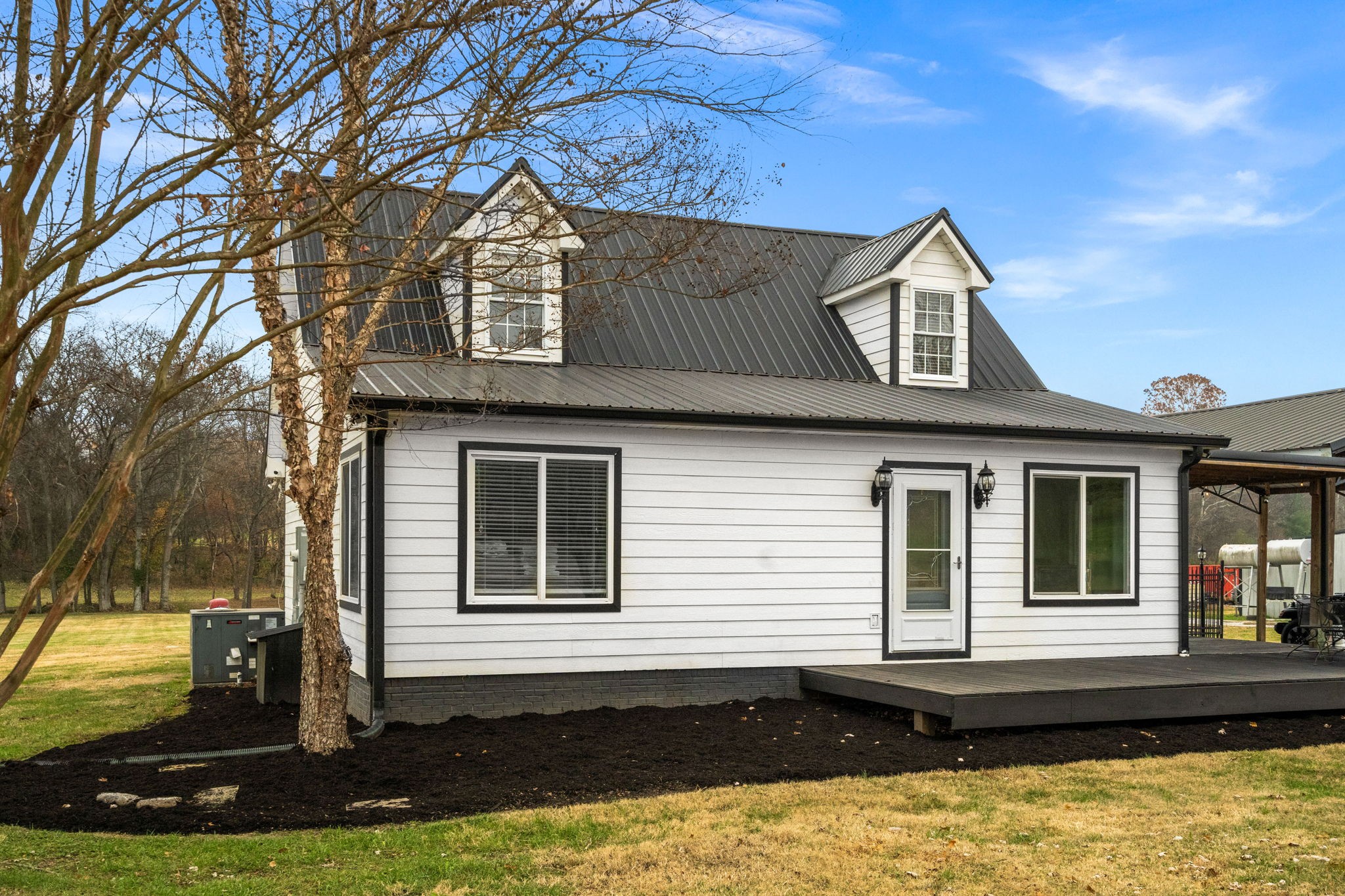 Beautifully updated ranch-style home on 5.59± acres offering 4 bedrooms, 3 baths, and 2,123 sq ft of light-filled living space. Enjoy a spacious great room and private primary suite, both added in 2021, along with new siding, metal roof, laundry room, and covered back porch. Outdoor features include an in-ground pool, peaceful walk to the creek, and multiple outbuildings ideal for equipment, hobbies, or livestock: 24x32 tool shop with water & 200-amp service, 40x60 equipment shed, 24x50 four-stall barn, and 10x16 storage building. Home has 400-amp service and a tankless gas water heater with owned propane tank. Convenient to I-24, Nashville, and Clarksville. Peaceful country living with modern upgrades—schedule your showing today!