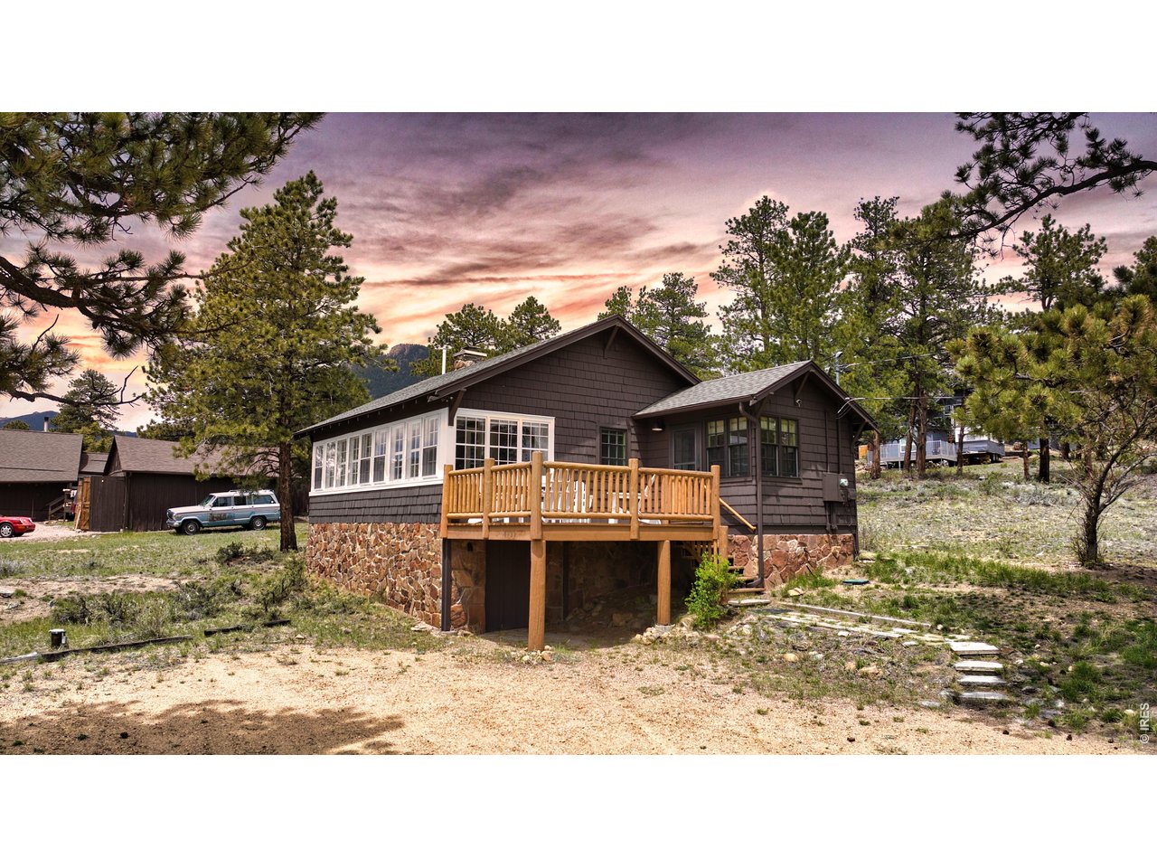 Rare opportunity to own a piece of Colorado heritage! Step into history with this enchanting 1930 rustic retreat, perfectly positioned in the prestigious High Drive neighborhood - just minutes from Beaver Meadows entrance to Rocky Mountain National Park. With sweeping views of Longs Peak, this 2-building property sits on .44 acres north of the Fall River corridor near the eastern border of RMNP. Remodeled 2006. With a total of ~1413 sf, the Main Cabin (~714 SF) is anchored by the original 1930 moss rock fireplace - a striking architectural centerpiece that seamlessly bridges the cozy fireside living space with the bright, sun-drenched dining room, blending historic hearth craftsmanship with an abundance of natural light. The galley kitchen blends vintage charm with modern convenience, while the primary bedroom features white-paneled walls and classic checkerboard flooring. Next, step outside to a beautiful deck with direct, spectacular views of Longs Peak.The adjacent 2-story Bunkhouse (~699 SF) offers 2 bedrooms and 2 bathrooms, ideal for guests or multi-generational living. Situated along national park boundaries, this property serves as a natural wildlife corridor - daily elk and deer sightings are the norm, not the exception. Ample parking and easy road access complete this one-of-a-kind Colorado mountain offering. This home has been a secondary home for decades but it is fully equipped for full-time living. Although it can be leased, the property is restricted to long term rentals (30 days or more) and as a single unit.