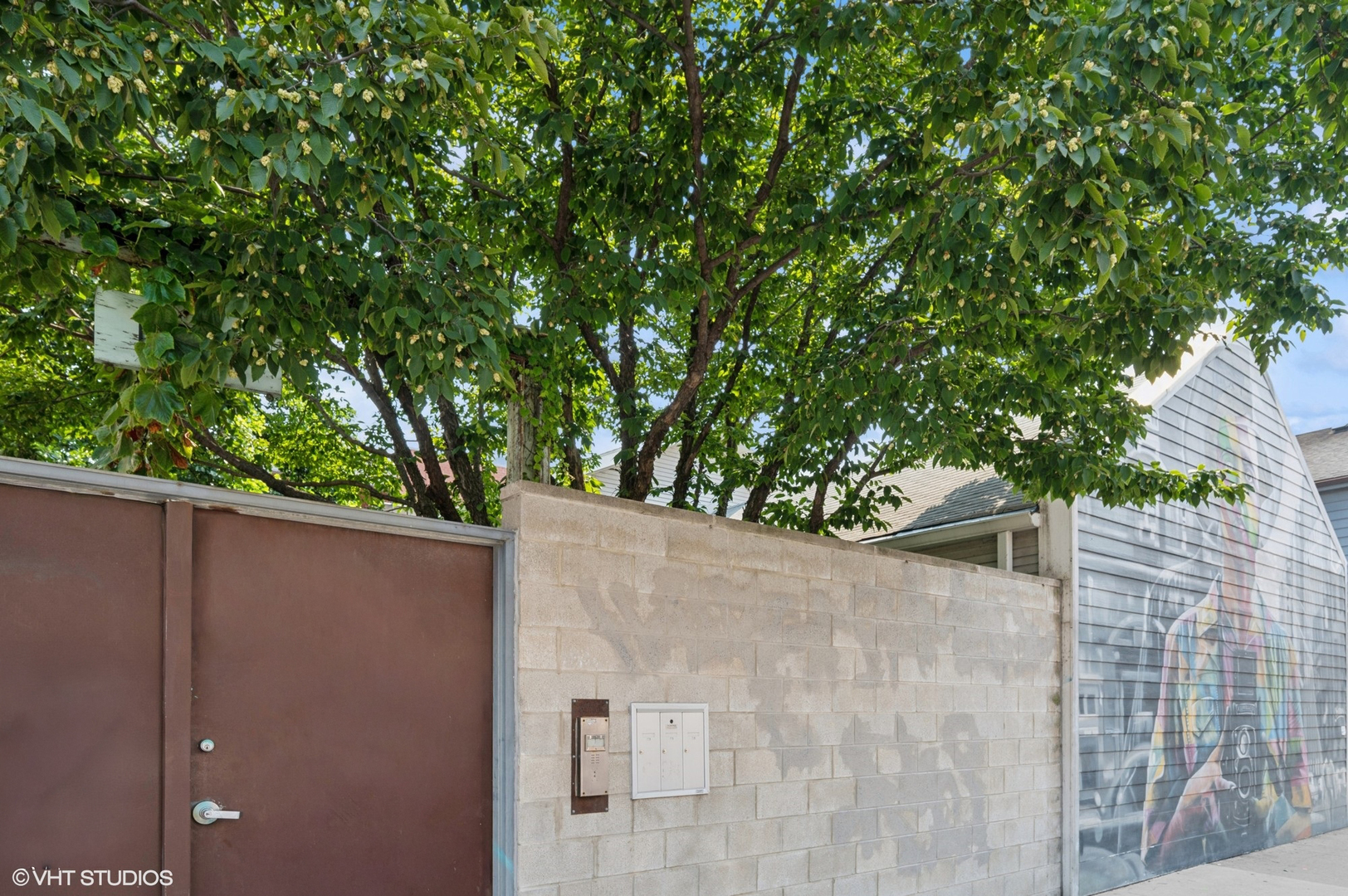 Incredible opportunity to own a truly one-of-a-kind, double-lot home in the heart of Bucktown-perfect for artists, creatives, or anyone seeking a unique live/workspace. Formerly a photo studio and art museum with adjacent living quarters, this 5BR, 3BA single-family home offers bold architectural features and unmatched character throughout. Enter through a private gated entrance with a famous Eduardo Kobra mural into a serene, landscaped urban oasis. The central courtyard-style deck and landscaped yard wrap the home in greenery, creating ideal indoor/outdoor flow. Main-level living includes a dramatic living/dining area with soaring beamed ceilings, a large open kitchen with adjacent family room and double-height ceilings, plus four bedrooms and two full baths. A second-floor addition offers a private bedroom and bath-perfect for guests or a home office. Updated mechanicals and systems, one-car attached garage, and an unfinished basement for storage or expansion. A rare creative retreat in a prime Bucktown location near shops, dining, and transit.