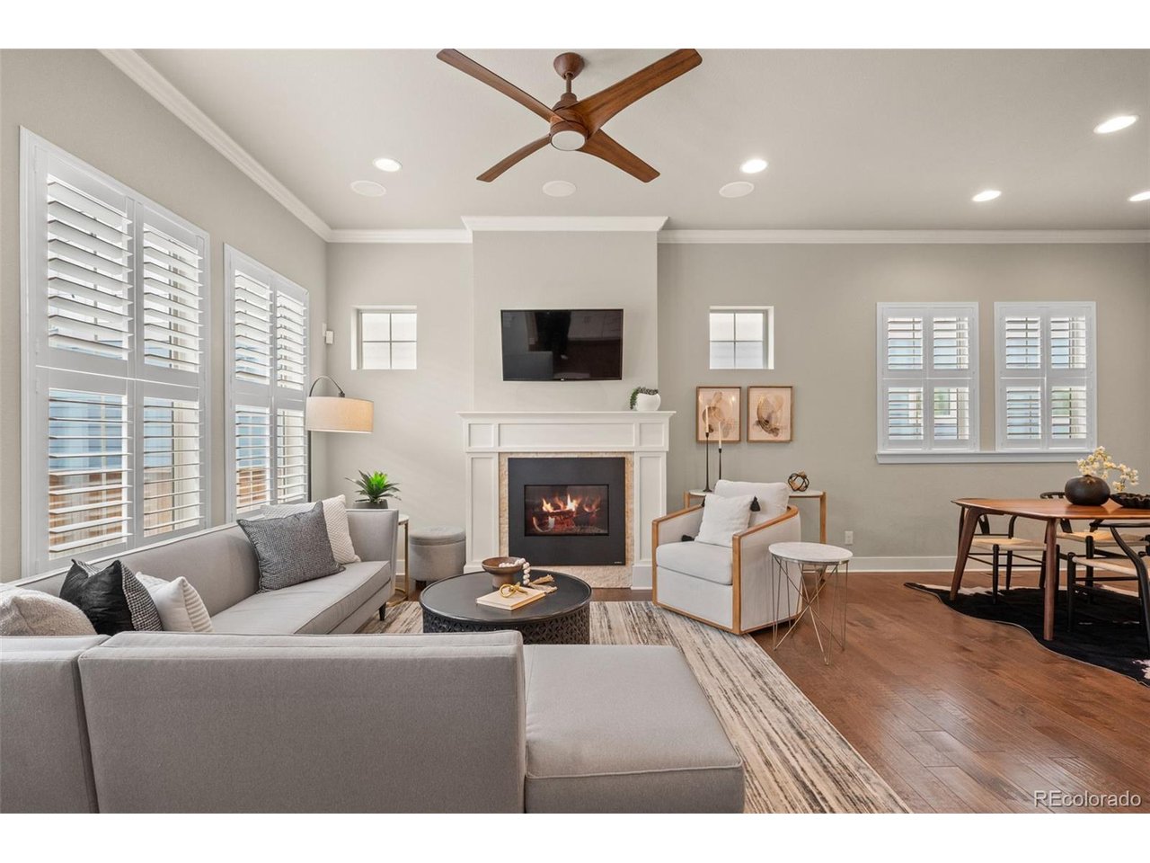 This stunning David Weekley paired home offers 3 bedrooms + a loft, 3.5 baths, & a finished basement; just blocks from the Splash Landing pool, trails, open space, & local schools. From the moment you step inside, soaring ceilings & large windows flood the home w/ natural light, while plantation shutters, rich hardwood flooring, and built-in speakers set a tone of warmth & sophistication throughout the open-concept main level. The kitchen has upgraded white cabinetry, granite counters, SS appliances, & a large center island. Extended cabinetry w/ built-in beverage cooler & open shelving above add both function & style. Breakfast bar seating flows seamlessly into the adjacent dining area, creating the perfect setting for family dinners & entertaining guests. The living room invites you to relax w/ a wall of south-facing windows & a stately gas fireplace w/ custom mantle. Rounding out the main level is a powder bath off the entryway & a convenient mudroom w/ built-in hooks & cubbies at the back door to keep daily life organized. Upstairs, the primary suite is complete with a spacious walk-in closet & a luxurious ensuite bath w/ dual-sink vanity & a generous walk-in shower w/ frameless glass enclosure. Motorized top-down, bottom-up shades offer the perfect balance of privacy & natural light. A secondary bedroom enjoys easy access to a full bath across the hall, while the versatile loft provides flexible space for a home office, playroom, or future 4th bedroom. The finished basement has a family room ready for game days, movie nights, sleepovers, and every gathering in between, as well as a bedroom w/ walk-in closet, a full bath, & laundry room. Step outside to a charming back patio w/ string lights; an effortless spot for alfresco dining or unwinding at the end of the day. The detached 2-car garage featuring an epoxy floor is just steps away. This home is beautifully appointed, thoughtfully designed, & perfectly positioned to enjoy everything Central Park has to offer.