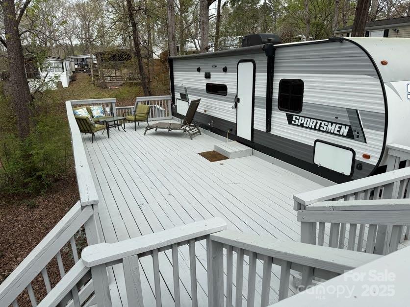 Badin Shores Resort is a private, gated community that includes access to a pool, lake, fishing piers, playgrounds and more. This lot includes a stationary fully furnished camper, a newly refinished deck with outdoor furniture, and an electric golf cart. Personal property will transfer with a bill of sale, but is included in the purchase price.

The camper includes a queen size bed in a private room and twin beds off the kitchen/living area. TVs in both areas will convey. One bathroom includes a standing shower. Full kitchen with a seating area for four and a comfortable love seat that extends into an additional bed round out the amenities of the camper. 

All decor, furnishings, linens, televisions, and accessories within the property and on the deck will remain after sale, making this property an investor's dream. Close one day and list on Airbnb the next, but don't forget to enjoy this getaway yourselves.