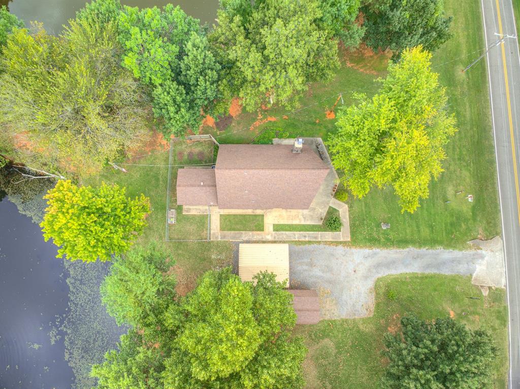 NEW PRICE!!  No HOA, no restrictions.  Just tranquility!  This beautiful picturesque property looks like a chalet, modeled after a Colorado cabin.  It has been in the same family for over 30 years.  Exceptionally well-maintained and includes 4.74 acres conveniently located just north of Hwy 9 West.  Newcastle schools.  This beauty includes 2 ponds, stocked with largemouth Bass, Black crappie & catfish.  There is a 2-story workshop, plus a large wooden deck overlooking the pond.  Exterior walls are 2X6.  5 large wooden beams in living space.  A quaint lava rock wood-burning fireplace with built-in fan to disperse warm air into the house.  Newer windows (2016), HVAC 2021, Roof 2015, New wood-look porcelain  (8"X35" tile) floors 2023.  New exterior french doors, including a 2nd-story leading out to a deck.  Imagine having your morning coffee on this deck overlooking the property.  You may even see deer or turkey with this beautiful view.  1 full bed and bath downstairs and 2 bedrooms, 1 bath upstairs.  One upstairs room could be a large game/flex room. New carpet Oct. 2025.  New quartz countertops in kitchen February, 2026.  Loads of storage throughout.  Easy access to Norman, Newcastle, OKC.  Could be a GREAT AirBnB, like a fishing cabin and also this close to casino and I-35 & I-44.