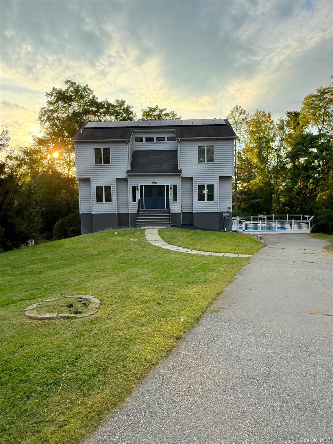 Perfectly situated on a serene, elevated lot, this 4-bedroom, 3.5-bath Colonial offers an ideal blend of modern updates and comfortable living spaces. From the welcoming two-story foyer to the expansive backyard oasis, every detail is designed for both relaxation and entertaining. The open-concept kitchen features stainless steel appliances, granite countertops, a central island, abundant cabinetry, and a stylish tile backsplash. The adjacent breakfast space opens to the back deck for effortless indoor-outdoor living. The large living room is highlighted by elegant wainscoting, a marble-surround fireplace, and plenty of natural light. Upstairs, the primary suite includes a spacious walk-in closet and a private bath with a soaking tub and dual vanities. Three additional bedrooms and multiple bathrooms provide comfort and convenience for family and guests. A finished basement offers a versatile recreation area perfect for games, a media room, or a home gym. Step into your private resort with an expansive multi-level deck, complete with covered lounge space, ceiling fans, and outdoor heaters for year-round enjoyment. Enjoy sunny days by the built-in pool, relax in the built-in fire pit lounge, or entertain guests in multiple seating and dining areas. The mature landscaping and surrounding trees provide privacy and a tranquil backdrop