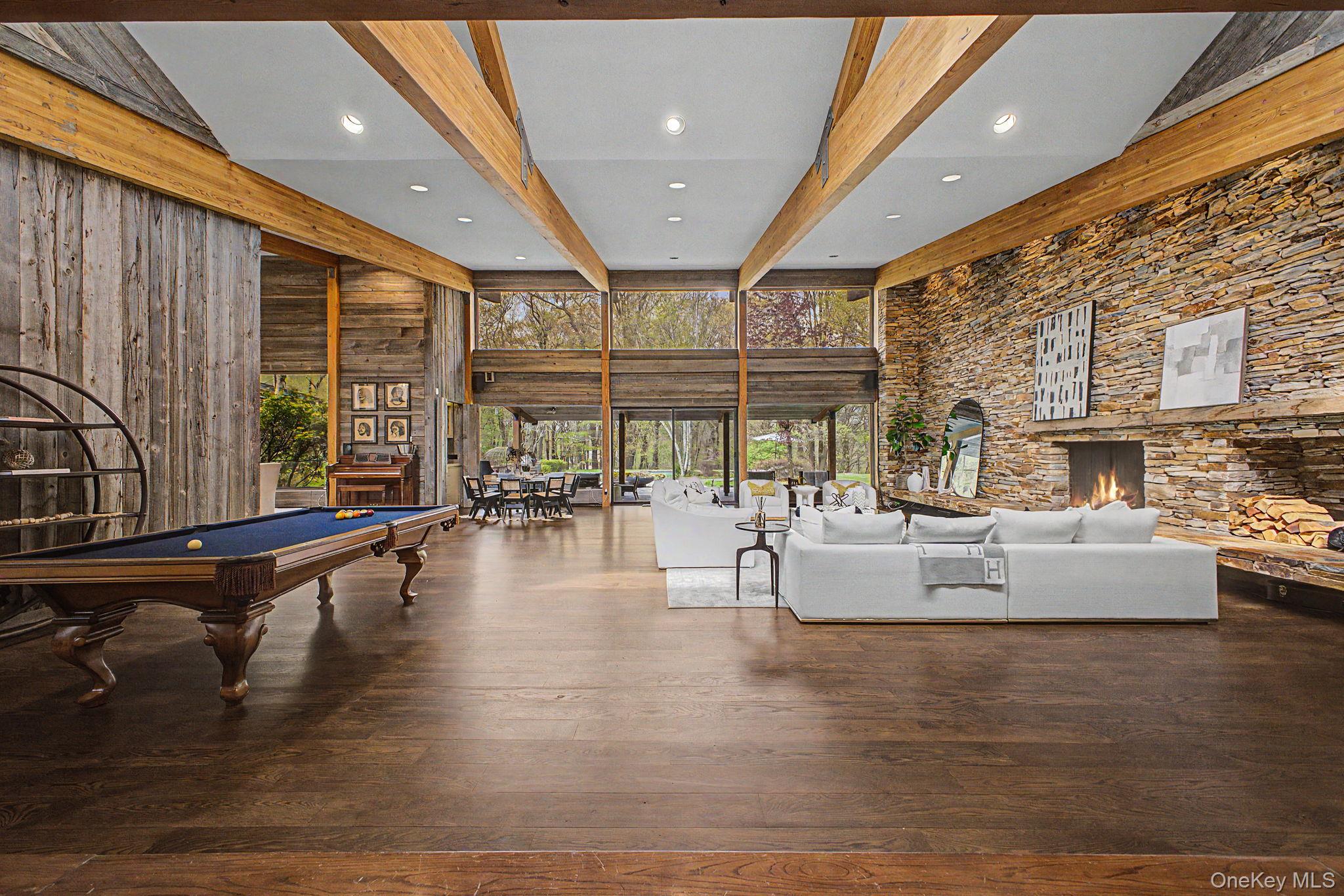 Welcome to 37 Sarles Street, Armonk — A Private Sanctuary of Sophistication and StyleNestled in one of Armonk’s most coveted locations, 37 Sarles Street offers a rare opportunity to own a truly exclusive 2.98 acre estate. This property provides unmatched privacy and a serene natural backdrop that will remain untouched for generations to come.From the moment you arrive, the home’s presence is undeniable. A sweeping driveway leads to a four-car garage, offering both convenience and grandeur. Step inside and be captivated by the soaring cathedral ceilings in the family room, where designer stonework on the interior wall creates a dramatic focal point. The space is flooded with natural light, blending elegance with warmth—perfect for both intimate evenings and lively gatherings.This home was designed with entertaining in mind. The resort-style backyard is a showstopper, featuring a sparkling saltwater pool, lush professional landscaping, a covered patio that functions as a full outdoor living room, and a sunset-facing hot tub. Whether you're hosting a summer soiree or enjoying a quiet evening under the stars, this space is a true extension of the home’s luxury lifestyle. Your guests will not want to leave.Inside, the amenities continue to impress. A gorgeous steam room offers a spa-like retreat, ideal for unwinding after a long day. The layout is both functional and refined, with generous living spaces, high-end finishes, and thoughtful details throughout.Beyond the property lines, 37 Sarles Street enjoys a prime location with easy access to the best of Westchester. You're just minutes from the charming town centers of Armonk, Bedford, and Chappaqua, with top-rated schools, fine dining, and boutique shopping all within reach. The proximity to major highways and Metro-North also makes commuting to Manhattan seamless. The nearby Westchester County Airport is also a quick uber away. This is more than a home—it’s a lifestyle. A rare blend of privacy, luxury, and convenience, 37 Sarles Street is a place where memories are made, and every day feels like a getaway.
