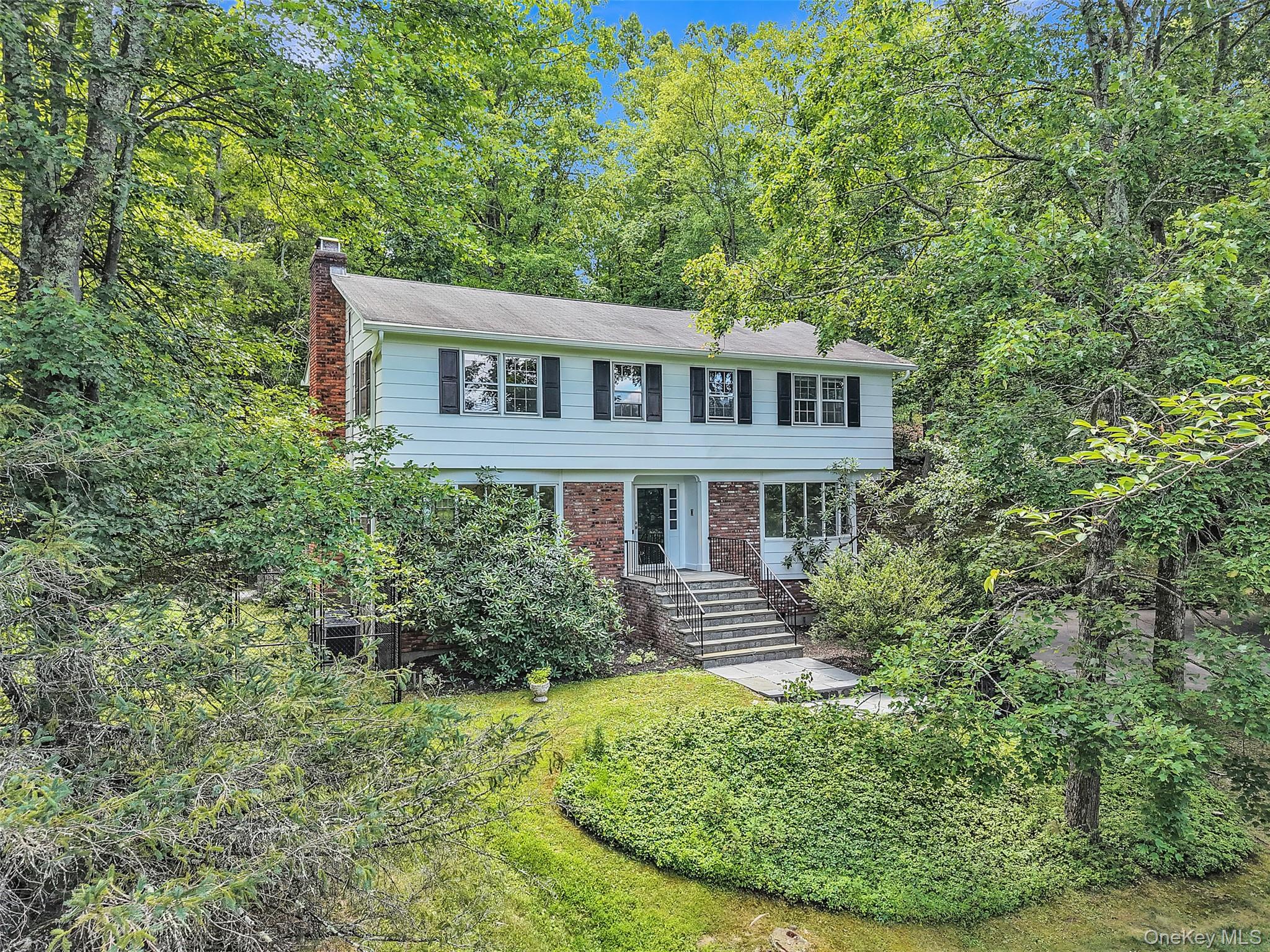 Tucked away in Cortlandt Manor in the Hendrick Hudson School System, nestled on a hill above a quiet, tree lined street is this spacious, classic 4BR,3 1/2 BTH colonial.  This property offers a rare blend of space, character, and comfort on nearly an acre of private land. Built in 1971 and thoughtfully maintained, the home retains its original charm while offering the practical updates today’s homeowners appreciate—like multi zoned central air conditioning, central vacuum, a freshly painted interior and exterior as well as beautifully buffed and shined hardwood floors throughout. Whether you’re looking to settle into a quieter lifestyle or simply enjoy more room to grow, this home offers the perfect balance of convenience and tranquility. Step inside to a welcoming and well-designed layout featuring a spacious living room with a large bay window and large, brick, wood-burning fireplace. The formal dining room, also with an oversized bay window, offers abundant natural light, perfect for gatherings. The heart of the home is the expansive, eat-in chef’s kitchen with generous prep space, a convenient powder room and direct access to the full-length Trex deck, ideal for entertaining or enjoying quiet evenings surrounded by nature. Upstairs, the serene primary suite includes a walk in closet and a full private bath with a shower/tub combination. Three additional bedrooms offer ample closet space and share a full hallway bathroom with classic tub and shower. Access to your large attic space. Every room reflects the home’s warmth and thoughtful care, not to mention you may feel like you are waking up in your own private treehouse from all of the bedrooms. The finished lower level adds flexible space that can serve as a workout area, yoga studio, pantry, office, or media room along with a third full bathroom. It also includes a laundry area and interior access to the oversized two-car garage, offering plenty of room for storage or hobby space. Savor endless summer gatherings on your private Trex deck, overlooking a beautifully landscaped backyard—your own peaceful retreat where nature invites exploration. A spacious, newly fenced enchanted garden awaits, thoughtfully designed for homesteading and outdoor living. Located in a quiet, established neighborhood, this home is just minutes from local schools, shops, and essential services. It’s also a commuter’s dream with quick access to the Taconic State Parkway and three nearby Metro-North stations. Local Highlights within and around Cortlandt Manor: Charles J. Cook Recreation Center & Pool, Croton Gorge Park & New Croton Dam, Cortlandt Waterfront Park, Hudson Highlands Gateway Park, Cortlandt Town Center.  Nearby Southern Westchester Attractions: Untermyer Gardens (Yonkers), Tibbetts Brook Park, Rockefeller State Park Preserve, Philipsburg Manor & Historic Sleepy Hollow.  The charming Rivertowns: Tarrytown, Irvington & Crotonville, The Bronx Zoo, New York Botanical Gardens.  With a perfect mix of natural beauty, community amenities, and easy access to the best of the Hudson Valley, this home invites you to create your next chapter.