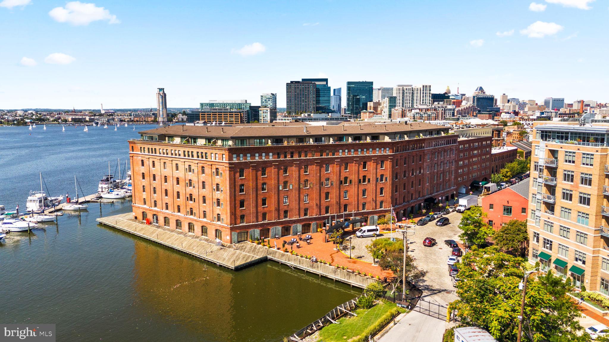 Nestled at the end of picturesque cobblestone streets in historic Fells Point, this spacious condo is located in Henderson’s Wharf—the premier luxury waterfront building in the area. Offering an unparalleled blend of charm, history, and modern convenience, this one-level home is perfect for both entertaining and everyday living.Inside, you’ll find an open-concept floor plan with abundant storage, a bright kitchen featuring stainless steel appliances, subway tile backsplash, open shelving, and a pass-through to the dining area for effortless hosting. The serene second-floor setting overlooks a private tree-lined courtyard, bathing the unit in natural light while providing a peaceful retreat.Additional highlights include: In-unit laundry with stackable washer & dryer, Updated flooring throughout, Two separate heating/cooling zones with individual thermostats, Owner-owned indoor parkingHenderson’s Wharf offers an impressive array of amenities: a 24-hour gym, modern lobby and guest lounge, full-service front desk with package concierge, secure entry, bike storage, and continuous building updates that reflect its high standards.Step outside your door to enjoy waterfront biking, running, and walking paths—or explore Fells Point’s renowned dining, shopping, and nightlife. With close proximity to major hospitals and new retail centers, this location balances convenience with lifestyle.Mortgage savings may be available for buyers of this listing.