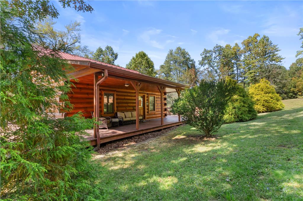 ENJOY THE CREEK VIEWS & SOUNDS!  Welcome to 313 Double Bridges Drive, a beautifully maintained 2BR, 2 BA log home nestled in Fancy Gap, VA. Built in 2013, this fully-furnished home offers vaulted ceilings, gleaming hardwood floors, a cozy fireplace and an open-concept layout perfect for everyday living or weekend getaways. The spacious kitchen features modern appliances, ample cabinet space and a seamless flow into the dining and living areas. Enjoy peaceful mornings on the covered porch listening to the creek & quiet evenings surrounded by wildlife on your private acreage. Located minutes from the Blue Ridge Parkway and I-77, this property combines the serenity of mountain living with easy access to trails, wineries and the Blue Ridge Parkway.