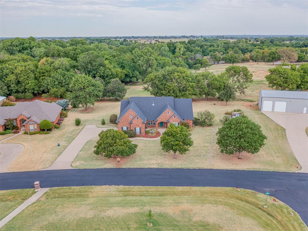 Welcome to 18775 308th Street in Coopers Creek Estates, where you can enjoy extra space and a peaceful setting while still having a Norman address and Norman Schools! Situated on an impressive 0.859-acre lot, this 2,518 sq ft home backs to a horse property, providing an open backyard feel with no home directly behind you.Inside, you'll find 4 bedrooms, 3 full bathrooms, 2 dining areas, an upstairs bonus room, and a 2-car garage. The split floor plan provides great separation between the primary suite and secondary bedrooms. The living room features beautiful hardwood flooring, a cathedral ceiling, fireplace, and custom built-ins. Upgraded architectural details continue throughout with crown molding, substantial trim work, columns, arched openings, and built-in storage.The kitchen offers abundant cabinetry, glass-front display cabinets, generous counter space, stainless steel appliances, and an adjoining dining area. A separate formal dining room provides additional space for entertaining.The primary suite includes a spacious bath with double sinks, soaking tub, separate tiled shower, and generous storage. Three additional bedrooms plus the upstairs bonus room provide plenty of flexibility for guests, hobbies, a playroom, or home office.Outside may be one of the best parts! The large covered back patio creates an inviting outdoor living space overlooking the nearly one-acre lot and neighboring horse property. A hot tub is included, and while there is currently no shop, the generous lot offers room to add one.Located in the Goldsby area with a Norman address and Norman Schools, this property offers a hard-to-find combination of space, privacy, character, and convenience—all with easy access to Norman.