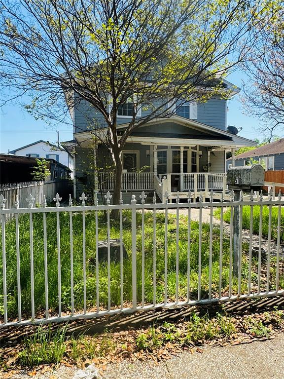 View of front of home with covered porch and a fenced front yard