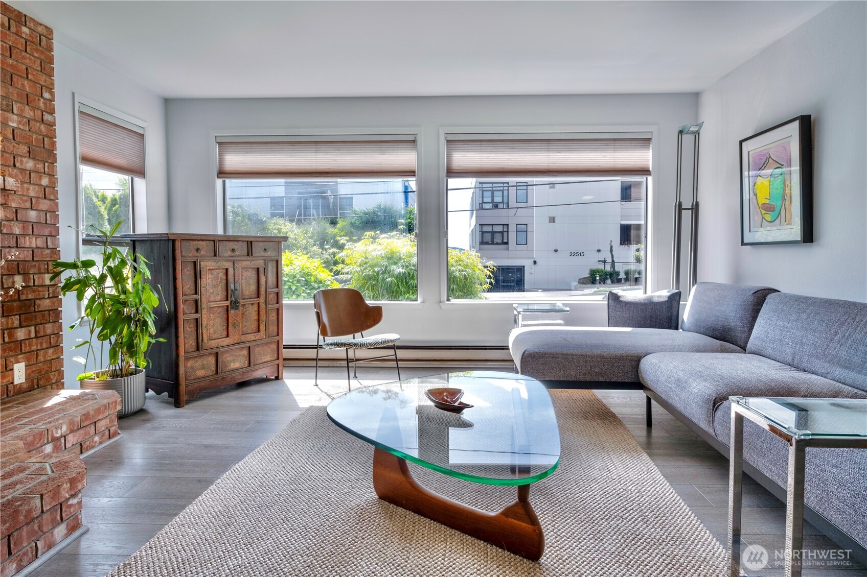Puget Sound charm just moments from the Des Moines waterfront. This stylish 2 bed, 1 bath Casa Del Mar condo offers a warm, light-filled layout with oversized windows, a brick hearth, freestanding wood stove, and partial Sound views. The enclosed sunroom extends the living space year-round—ideal for morning coffee, reading, or taking in the view. The efficient galley kitchen features generous cabinetry, newer stainless appliances, and easy flow to the dining area. Recent owner updates include stainless kitchen appliances, washer/dryer, and water heater. Both bedrooms are comfortably sized with updated flooring and good storage. Assigned off-street parking and garage-level storage included. Enjoy a boutique 9-unit building near Des Moines Marina, Beach Park, restaurants, trails, farmers market, and waterfront events.