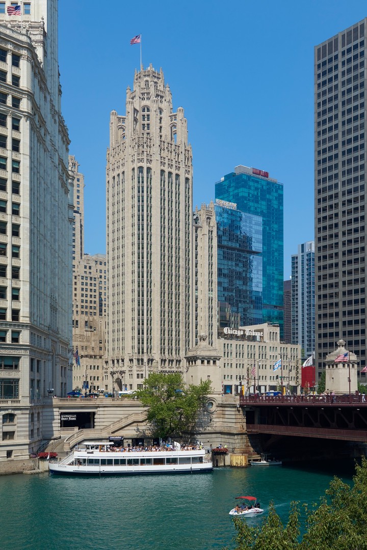 A rare turnkey 3 bedroom + den residence with one of the most architecturally significant private outdoor spaces in Chicago. The terrace is framed by original Gothic limestone with panoramic views of Lake Michigan, the Chicago River, and city skyline in the iconic Tribune Tower. 2203 seamlessly blends architectural pedigree with cutting-edge elegant design. A gracious foyer leads to the open-concept living and dining area framed by oversized windows with sweeping views of Michigan Avenue. Exquisite custom millwork, designer lighting, and a dramatic marble fireplace anchor the space. The chef's kitchen is impeccably appointed with integrated Wolf, Sub-Zero, and Miele appliances, custom cabinetry, and a wine tower. The primary suite is a serene retreat offering bespoke closets and a spa-caliber bath clad in marble featuring a deep soaking tub, oversized glass-enclosed shower, and dual vanity. Two secondary en-suite bedrooms provide exceptional comfort and privacy. A sophisticated bar creates an intimate and distinctive entertaining space leading to the professionally landscaped terrace outfitted with an outdoor kitchen, lounge area with a fire table, and built-in dining area. Crestron home automation with surround sound and motorized shades throughout and 3 prime parking spaces on main level. Tribune Tower residents enjoy unparalleled amenities including an indoor pool and adjacent sundeck, state-of-the-art fitness center with spa and treatment rooms, golf simulator, resident lounges, private elevated park, the 25th-floor Crown Terrace, covered dog run, and 24/7 door staff with onsite property management.