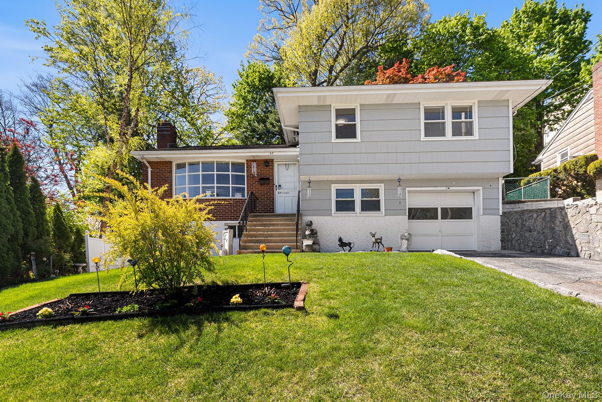 This well-maintained split level checks all the boxes and then some. Hardwood floors run through the main and upper levels, and the finished walkout basement features brand new LVP flooring and carpet, both installed in 2024. The basement also includes a summer kitchen, making it a great space for entertaining or extended family use. Updated bathrooms give the home a fresh, move-in ready feel. Outside you'll find a private yard, off-street parking, and a well-kept perennial front garden that adds color throughout the warmer months. Conveniently located near shopping, dining, and parks, within walking distance to public transportation, with easy access to the Saw Mill River Parkway and just minutes to Ridge Hill for dining, retail, and entertainment