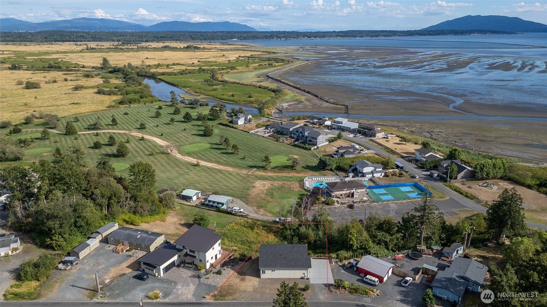 Perched above Sandy Point Golf Course, this home showcases sweeping bay, island, and mountain views. With 1,857 square feet of thoughtfully designed space, this 3 bedroom, 2.25 bath home offers main floor living with high ceilings, a wall of windows, and a spacious primary bedroom with an oversized walk in closet and dedicated vanity area. The gourmet kitchen features granite counters and a butler's pantry, opening to a large al fresco dining area with custom bifold windows, perfect for entertaining while enjoying breathtaking sunsets. Upstairs, two additional bedrooms and a large rec space offer flexibility for a media room, play area, or guest retreat. A private trail right out the back door leads to community amenities including a pool, golf course, and pickleball court.