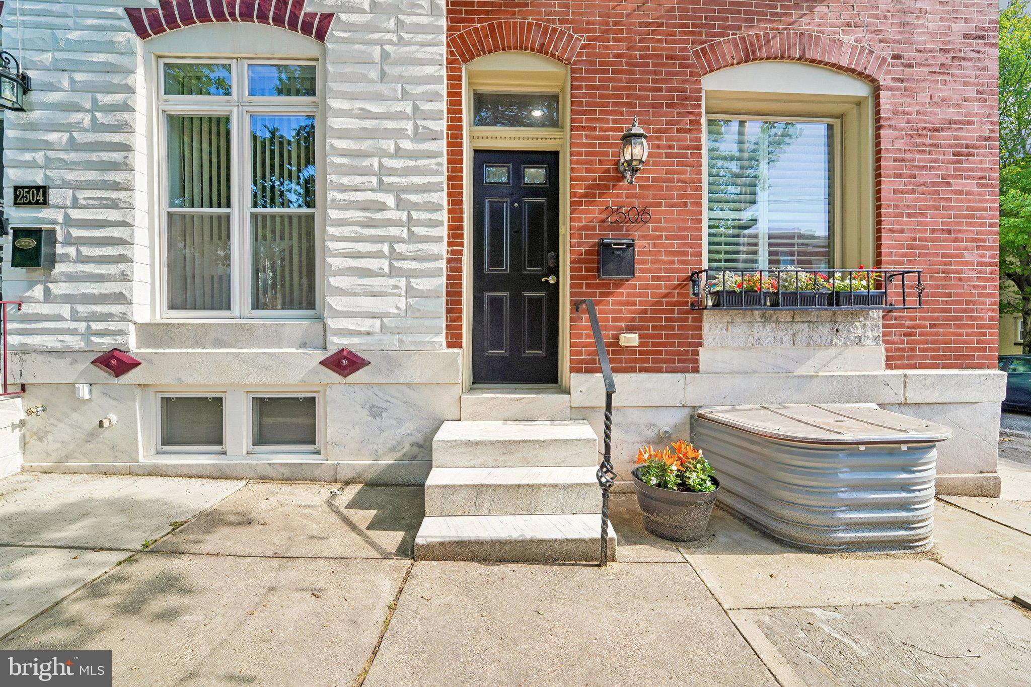 NOW AVAILABLE!  Located just a block from iconic Patterson Park, this stunning oversized Baltimore rowhome perfectly blends modern style with timeless charm. Offering 4 bedrooms and 3.5 bathrooms across multiple finished levels, this home delivers the space, character, and city lifestyle buyers dream about.Step inside to an inviting open-concept main level featuring a cozy fireplace, sleek modern stair design, and an effortless flow between the living area, dining space, and kitchen. Just off the kitchen, step outside to a private deck overlooking a beautifully designed patio retreat, creating the perfect setting for entertaining, relaxing, or enjoying quiet evenings in the city.Upstairs, the spacious front primary suite impresses with elegant tray ceilings and a private ensuite bathroom. Two additional bedrooms and another full bathroom complete the upper level, including a rear bedroom with its own private balcony/deck for a unique outdoor escape.The finished lower level adds incredible flexibility with a fourth bedroom, full bathroom, and dedicated laundry room, ideal for guests, roommates, a home office, or additional living space.With its spacious layout, thoughtful updates, outdoor living spaces, and unbeatable location just a block from Patterson Park, this home offers the perfect balance of classic Baltimore character and modern convenience.