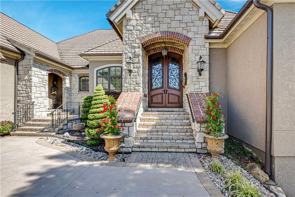 Experience luxury living in this stunning Reverse 1.5-Story Evan-Talon built home located in the highly sought-after St. James Court neighborhood of Loch Lloyd. Perfectly positioned backing to the prestigious Loch Lloyd Golf Course, this 4-bedroom residence (featuring 2 on the main floor) blends exceptional craftsmanship with modern comfort. Designed for both elegance and functionality, the home features 4 full baths, 2 half baths, a whole home instant hot water system, a dedicated workout room, and a spacious private office. The walkout/walk-up lower level is an entertainer’s dream, complete with a full bar, dishwasher, drawer refrigerator, and beautifully terraced patio, that leads up to a main level patio and enclosed sunroom overlooking serene golf course views. Enjoy year-round comfort with a 3 Unit, 5-zone HVAC system and peace of mind with a Generac backup generator. The home is also elevator-ready, offering a pre-installed elevator shaft for future installation. A rare opportunity to own a meticulously maintained, thoughtfully designed home in one of Loch Lloyd’s most desirable enclaves.