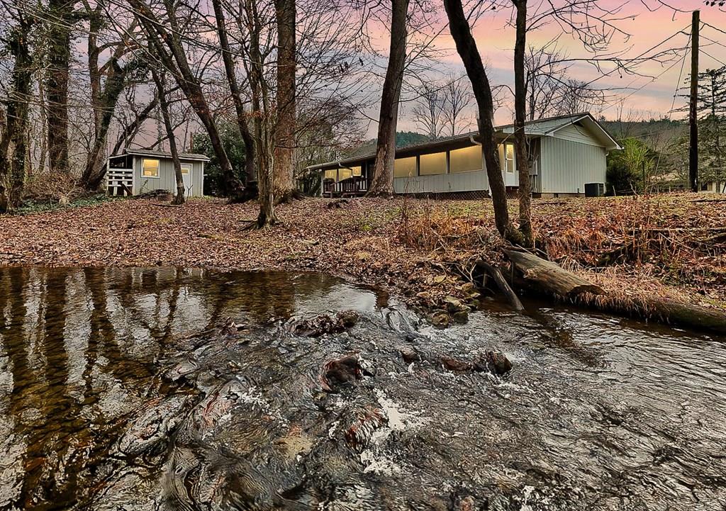 Charming 3-bedroom, 2-bath home nestled along a beautiful creek. Enjoy peaceful, year-round water views right from the master bedroom, kitchen, dining room, and the spacious back porch. This home offers a warm, inviting layout with plenty of natural light and the soothing sound of flowing water just outside your door. The extra lot provides ample space for a garden, outdoor activities, or creating your own creekside retreat. Perfect for relaxing, entertaining, or simply taking in the serene setting.