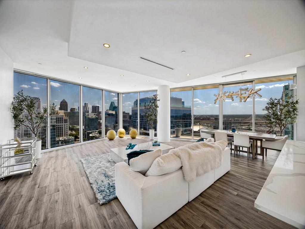 Experience elevated Dallas living from this exceptional 23rd-floor residence at The Azure, where sophisticated interiors meet sweeping, unobstructed views of the city skyline. A rare three-bedroom floor plan, this remarkable home is framed by floor-to-ceiling glass, 9- to 10-foot ceilings and expansive vistas that can be enjoyed from nearly every living and sleeping space. Rich hardwood floors flow throughout the open-concept interior, creating an inviting backdrop for both everyday living and effortless entertaining. Designed for the culinary enthusiast, the striking kitchen is appointed with a complete suite of Miele appliances, including double convection ovens, a built-in coffee and espresso system and six-burner gas cooktop, complemented by a Sub-Zero refrigerator and impressive six-foot, two-temperature wine cooler. The residence offers two generously sized primary suites, each featuring a gas fireplace and private access to the expansive covered terrace. The primary retreat provides a serene escape with captivating city views, a spa-inspired bath and thoughtfully designed walk-in closet, while the second suite offers exceptional privacy and flexibility for guests. A third bedroom provides additional accommodations and could easily serve as a sophisticated home office or personalized flex space. The expansive terrace creates a seamless extension of the living areas and offers an extraordinary setting for morning coffee, sunset cocktails or evenings overlooking the illuminated Dallas skyline. Life at The Azure is defined by exceptional service & resort-style amenities, including 24-hour concierge & valet service, state-of-the-art fitness center, resort pool & spa, theater, social room, two private storage lockers and a private four-car garage. Ideally positioned near the Katy Trail, acclaimed dining, Uptown, the Harwood District and American Airlines Center, this residence delivers a rare combination of privacy, luxury, convenience and panoramic city living.