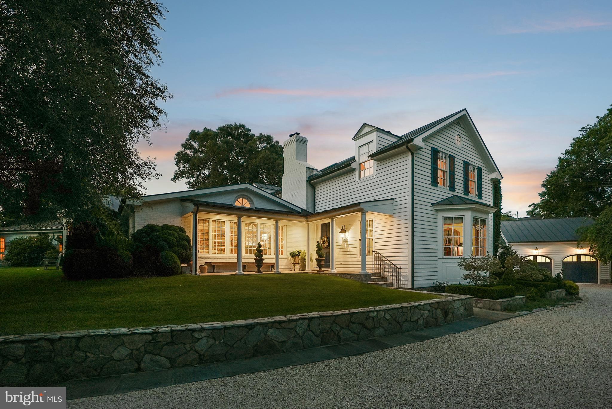 This charming estate is located at the end of a private drive on one of Alexandria's most sought-after streets. Featuring 1.37 landscaped acres, this home offers country estate privacy that is easily accessible to Old Town, Washington, DC, and Reagan National Airport.  The 5,119 square foot main residence was designed as a spacious classic farmhouse, where every window frames the gardens and extensive lawns. Reimagined by a builder and gardener for their family, the home’s elegant custom architectural details include high ceilings up to twelve feet, centuries-old heart of pine floors and library built-ins, four fireplaces, seven bathrooms and three primary suites. The large kitchen with family/breakfast area includes two working areas with sinks and a cozy office. A first-floor primary suite has a dressing room, two full baths and walk-in closets. Steps away is a laundry/home keeping room with its own outside entrance.Several outbuildings are integral parts of the estate’s charm and unique character- a lovely guesthouse adjacent to the in-ground pool area, an oversized two-story garage with attic and four storage bays and a custom imported glasshouse from England. The setting of the property, its privacy and improvements, would make you think it was the Virginia countryside! The property's grounds feature several gardens, which were showcased during the national Garden Conservancy's 2025 Open Days event. Stately oaks, boxwoods, topiaries, rare conifers, shrubs and a woodland walk ensure year-round interest in the landscape of this legacy property