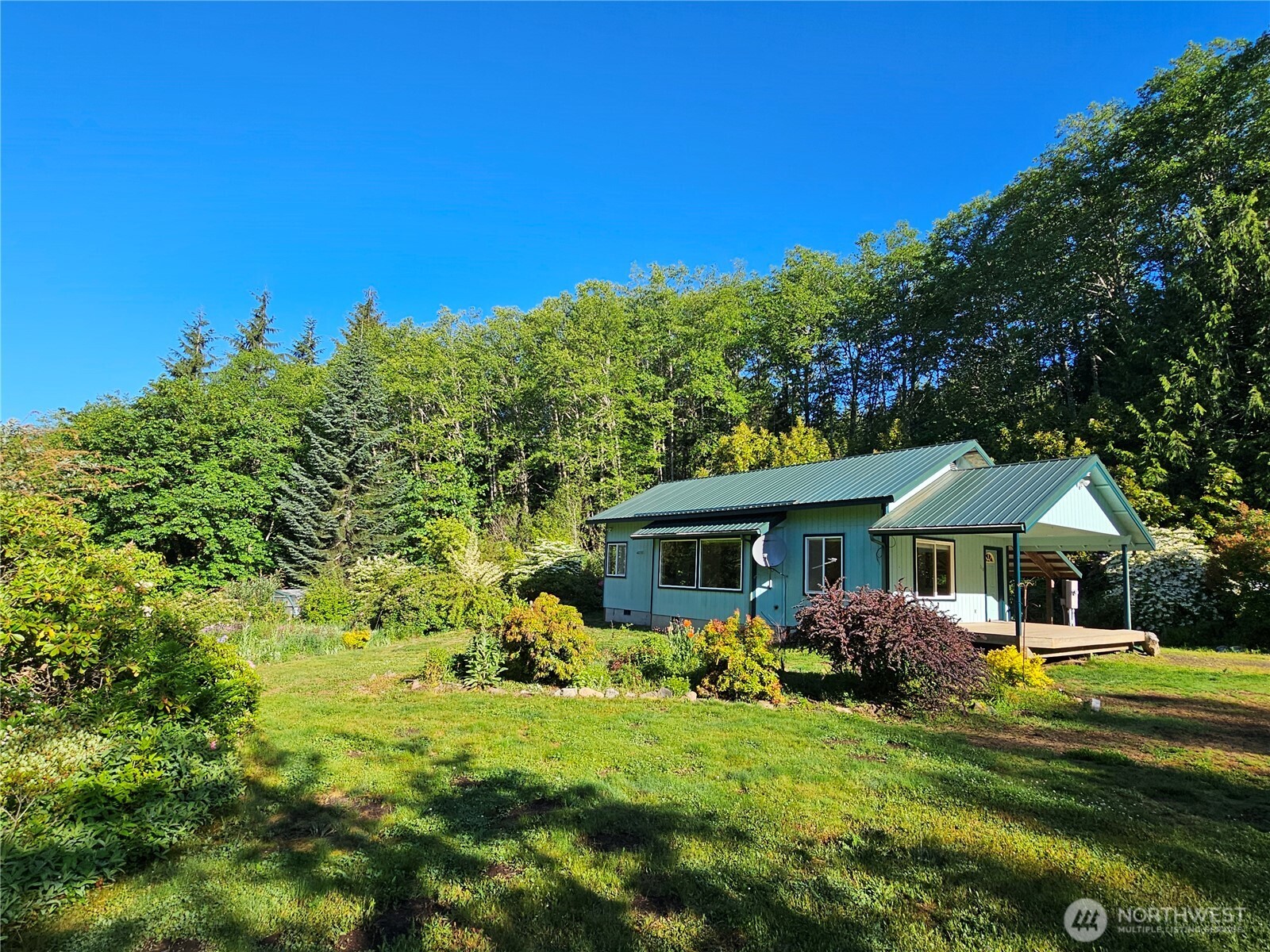 Escape to your private retreat with this well-maintained 1BR/1BA/954sqft stick build, 3-bed septic nestled on 5 acres. Designed for comfort & connection to nature, this cozy residence features large windows that bring in natural light and provide picturesque views of the surrounding flower & tree gardens. Enjoy the best of country living, w/garden, greenhouse, garage, vibrant landscaping, dedicated pump house, 6 ft wraparound fencing & 2 drive through gates, the property borders timberlands. Trail to running creek w/benches rear of parcel. Outdoor enthusiasts will love the location-just a short drive to beautiful lakes, mountains, and scenic hiking trails, and a popular ski resort, making this the perfect year-round haven or vacation home.
