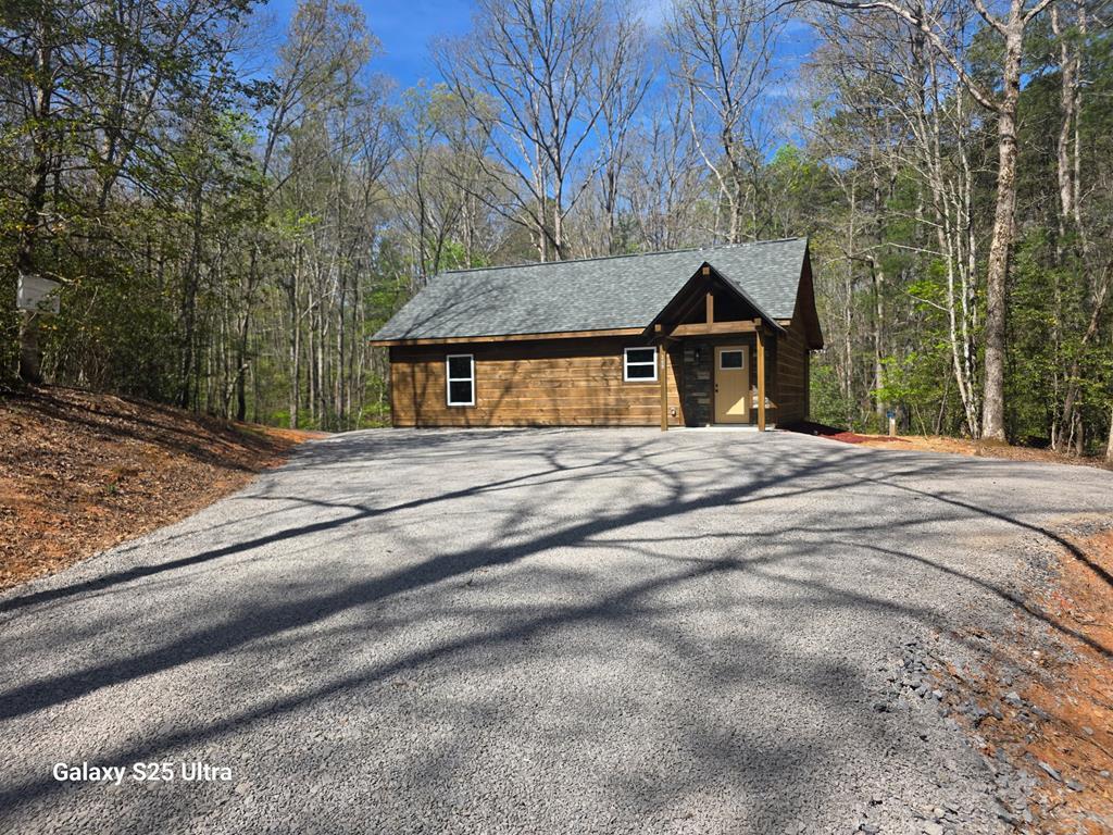 Discover this unique, brand-new 2-bedroom, 2-bath cabin offering the perfect blend of privacy and convenience. Tucked away on a quiet property just off a state-maintained road, this home is ideally located only 10 minutes from downtown Murphy and 20 minutes from downtown Blue Ridge. Situated on 1.20 acres of unrestricted land, this property is not part of a subdivision, giving you the freedom and flexibility you've been looking for. The exterior showcases beautiful log siding with striking rock accents, creating a true mountain retreat feel. Step inside to find a warm, inviting interior featuring all-wood walls and richly stained ceilings throughout. The open living space is designed for both comfort and entertaining, with durable luxury vinyl flooring that's perfect for pets and everyday living. The kitchen boasts pine cabinetry, granite countertops, and flows seamlessly into the living area, complete with a cozy gas fireplace. Both bedrooms feature vaulted ceilings, enhancing the spacious feel. The primary suite includes a walk-in closet and a beautifully tiled shower in the ensuite bath. This charming cabin is the ideal full-time residence, vacation getaway, or investment opportunity. Don't miss your chance to make it yours!