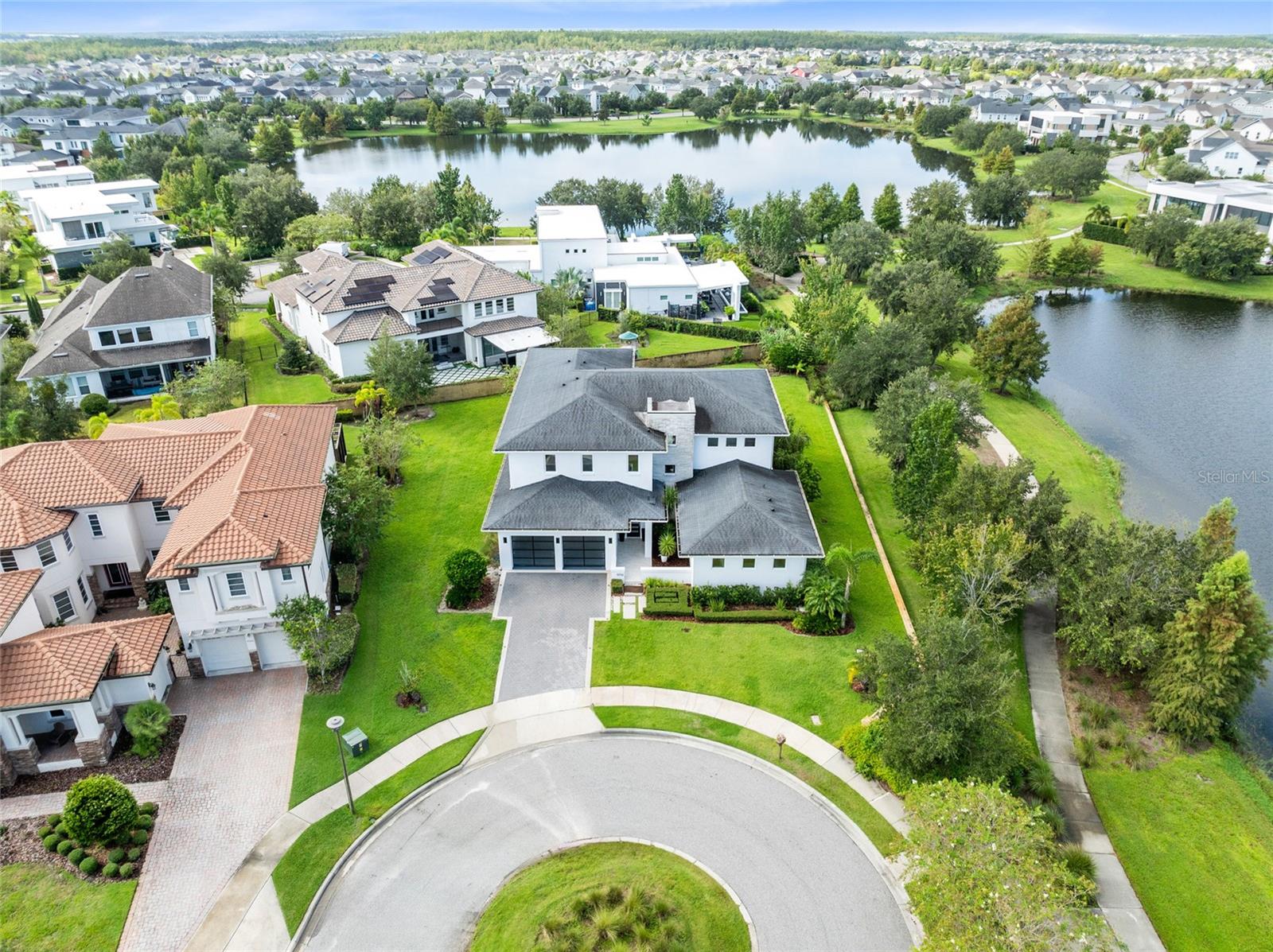 One or more photo(s) has been virtually staged. This one-of-a-kind custom residence by the renowned Phil Kean Design Group redefines modern lakefront living in Laureate Park. A true architectural masterpiece, it offers 4,519 sq. ft. of heated living space and 6,074 sq. ft. total under roof, blending sleek design with everyday comfort. With five bedrooms, four full bathrooms, and one half bathroom, this is the only home of its kind in the community.

The heart of the home is the expansive great room with soaring ceilings, $20K designer chandeliers, and walls of glass that flood the space with natural light. The chef’s kitchen showcases waterfall-edge quartz countertops, custom cabinetry, premium appliances, and a large island with seating. Seamless indoor-outdoor living extends through sliding glass doors to the covered lanai and backyard with peaceful lake views.

The first floor offers versatility with a full guest suite and a spacious primary suite featuring a spa-like bath and walk-in closet. Upstairs, a second primary suite provides private balcony access, a luxurious bath, and a custom closet. Additional bedrooms and baths ensure comfort for family or guests, while the oversized bonus room serves as the perfect entertainment lounge with space for both seating and games.

Step outside to enjoy multiple outdoor living areas, including the expansive lanai designed for dining and lounging, and an upper balcony with sweeping water views. The lush, oversized backyard is one of the largest in Laureate Park—ideal for creating your dream pool, outdoor kitchen, or garden oasis, while still leaving plenty of open green space for play and entertaining.

Laureate Park isn’t just a neighborhood—it’s a vibrant lifestyle. Enjoy the Aquatic Center, resort-style pools, LP Fit gym, and 44+ miles of trails. Located in prime Lake Nona, minutes from Medical City, the VA hospital, Nemours, dining, and shopping. Close to major highways, Orlando International Airport, and the USTA National Campus. Easy access to Orlando’s top theme parks and beautiful Florida beaches.

This Phil Kean Design Group original blends architectural distinction, space, and community in a sought-after location. Schedule your private showing today and experience the best of Lake Nona living.