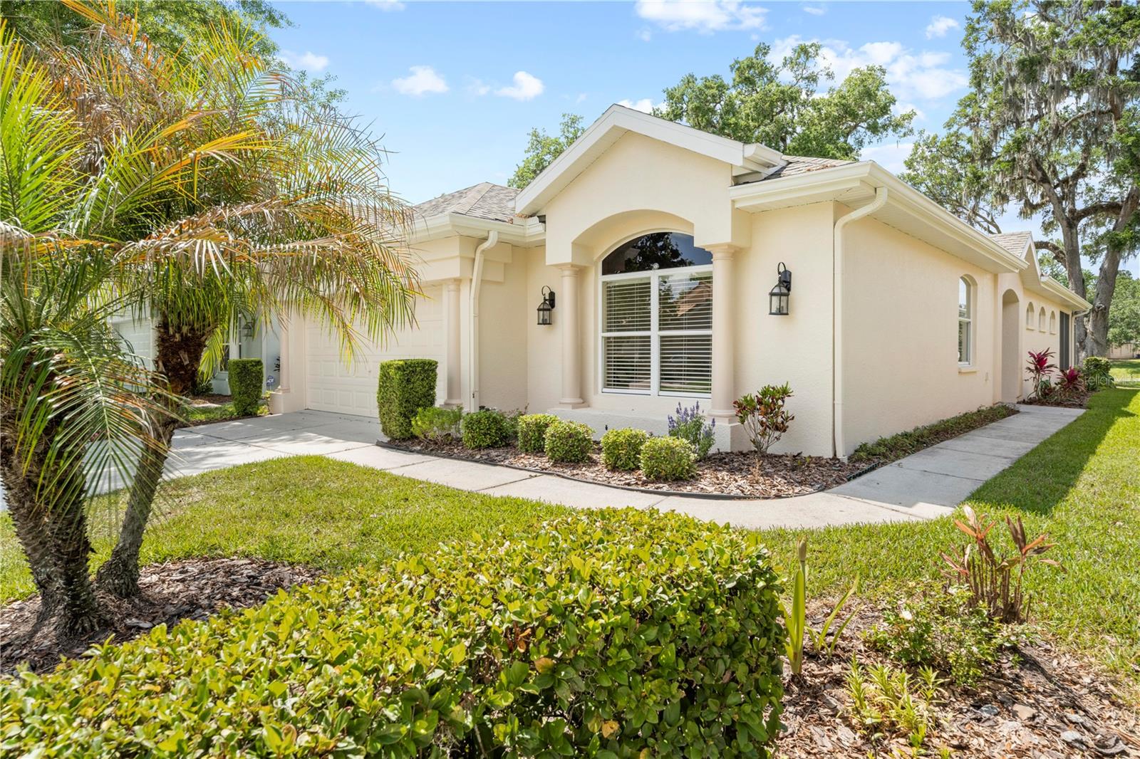 This beautifully designed Palmwood Martinique model offers just over 2,000 square feet of low-maintenance living with peaceful golf course views and plenty of privacy. Step through the double-door entry into a bright, welcoming foyer with elegant columns leading you into a spacious living room. You'll love the custom boxed ceiling, natural gas fireplace with granite surround, and the 3 stained glass windows that fill the space with soft natural light. Two sets of French doors open to a large screened lanai, the perfect spot to unwind and take in the view of the 8th hole.There's room for everyone with 3 bedrooms, 2 full baths, and a 2-car garage. The layout offers both a formal dining room and a sunny breakfast nook, while the kitchen brings it all together with granite countertops, custom cabinetry topped with crown molding, a tiled backsplash, and a breakfast bar for casual meals. The primary suite is tucked away for privacy and includes a tray ceiling, two walk-in closets, and a roomy ensuite bath with a step-in shower, dual sinks, and a makeup area. The guest bedrooms are spacious and comfortable, with the oversized third bedroom making a great office, media room, or flex space. The guest bath is just as nicely finished with a tiled shower and granite-topped vanity. There is porcelain tile in all the main living areas and carpet (installed 5/2025) in two bedrooms. The laundry room includes a utility sink, walk-in pantry, and extra storage—plus, the washer and dryer are included. Arched doorways, a programmable thermostat, pull-down attic stairs in the garage, Roof (2023) and A/C (2022).Hernando Oaks is a gated, deed-restricted community that takes care of the exterior paint, lawn mowing, pest control, mulch, fertilizer, and sprinkler maintenance—so you can focus more on enjoying life and less on chores. It's close to shopping, hospitals, and the Suncoast Parkway for an easy trip to Tampa International Airport. And let's not forget the golf! You'll live on the Scott Pate-designed 18-hole course that stretches nearly 7,000 yards for a par-72 experience. This home checks all the boxes for comfort, convenience, and easy Florida living.