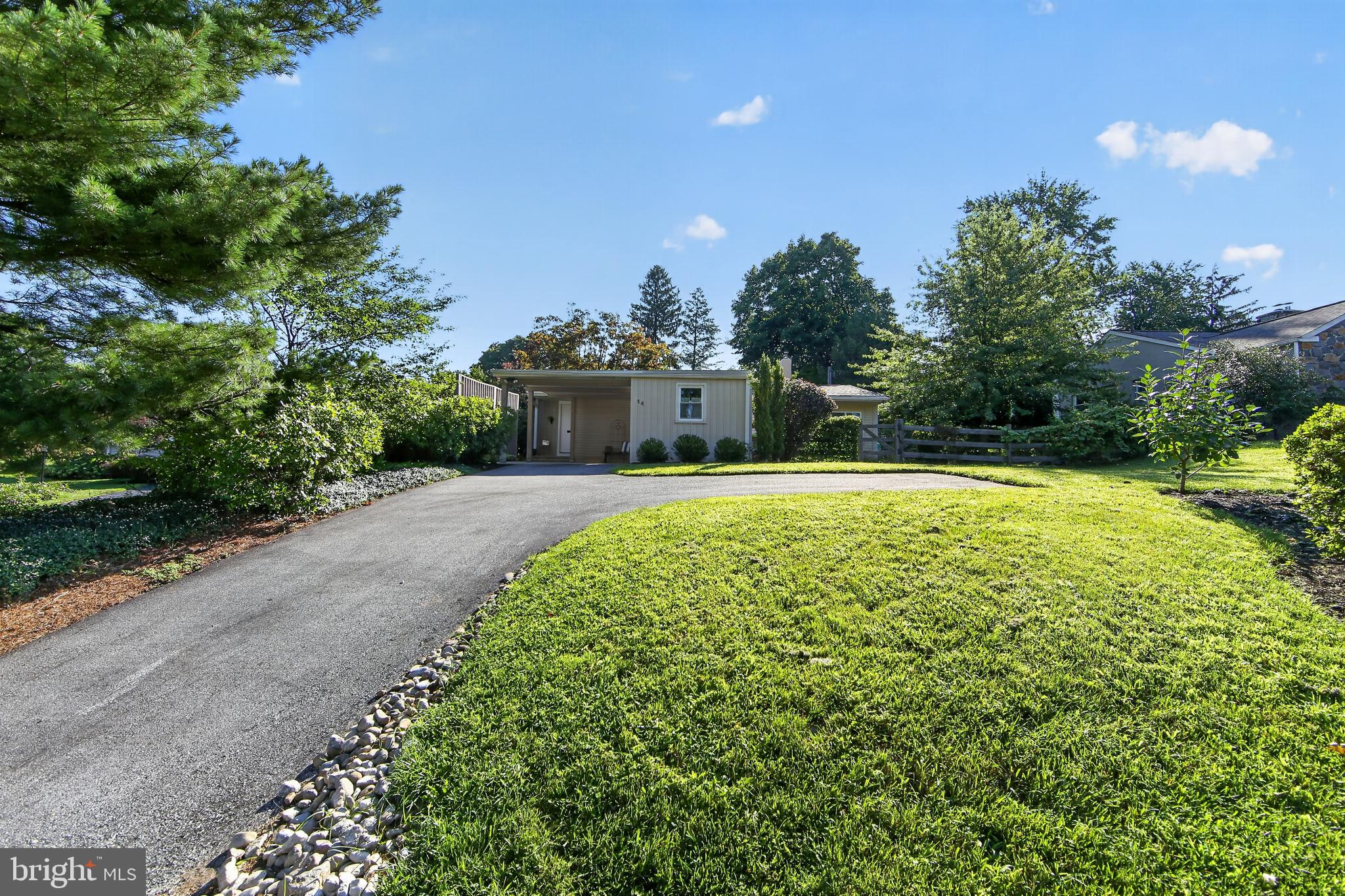 Welcome to 14 W Golf Club Lane, where distinctive mid-century character, sun-filled interiors, one-level living, and resort-like outdoor living come together in a truly special Paoli home. Set on approximately 0.34 acres in the award-winning Tredyffrin-Easttown School District, this three-bedroom, two-bath ranch offers 1,509 square feet of thoughtfully designed, single-level, open, sun-filled living space. Step inside to discover an inviting interior filled with lots of natural light. Hardwood floors extend through the main living and dining spaces, complemented by vaulted ceilings, skylights, recessed lighting, and walls of windows. The bright white galley kitchen features cork flooring, butcher-block countertops, abundant cabinetry, open display shelving, and an efficient layout that keeps everything within easy reach. The adjoining dining area opens to a private, front brick patio, allowing entertaining to flow effortlessly outdoors. There is a garden shed in this space that can easily be changed into an outdoor bar area. The spacious living room is anchored by a fireplace and enhanced by custom built-in shelving, creating a warm and welcoming place to gather. One of the home’s most memorable spaces is the cozy sunroom, which features Saltillo tile flooring, skylights, and oversized windows that frame serene views of the backyard. Whether used for quiet mornings, casual entertaining, or simply enjoying the changing seasons, this room offers a peaceful retreat. The sliding glass doors from this room lead out to the brick patio…the perfect space for outdoor relaxing. The primary suite features its own private full bathroom with a beautifully tiled walk-in shower. Two additional bedrooms share a second full bathroom, which offers custom cabinetry, a combination washer/dryer, a large linen closet, and the rare convenience of direct exterior access to the pool area ( cement pool 18 X 36), —an especially thoughtful feature for swimmers and outdoor guests. The full unfinished basement is a valuable space for added living space and storage. Step outside and discover a lush private backyard oasis surrounded by mature trees and established gardens. Multiple brick patios provide inviting spaces for dining, lounging, and entertaining, while the in-ground pool sets the stage for memorable summer days. The home's distinctive character reflects its origins: the previous owner was an architect who envisioned a Japanese-inspired retreat, evident in its strong connection to the outdoors, numerous exterior doors, and, originally,  he had koi ponds built in the back of the home. Since purchasing the home with just one bathroom, the current owners added square footage to the Primary bedroom at the back of the house to accommodate a second full bathroom. Additional improvements include installing a sump pump in the existing basement sump pit, adding underground drainage behind the home, and removing a former backyard koi pond. That area was then regraded and connected to the enhanced underground drainage system to improve rainwater management around the property. Ideally situated in a beautiful, walkable neighborhood, this unique home offers easy access to Lancaster Avenue/Route 30, Routes 202 and 252, I-76, the Pennsylvania Turnpike, and Paoli Station for regional rail and Amtrak service. Enjoy the shops and restaurants of the Main Line just minutes away, as well as the natural beauty and historic trails of Valley Forge National Historical Park. A home with this much character, one-level living, and outdoor appeal is a rare find—Welcome home…