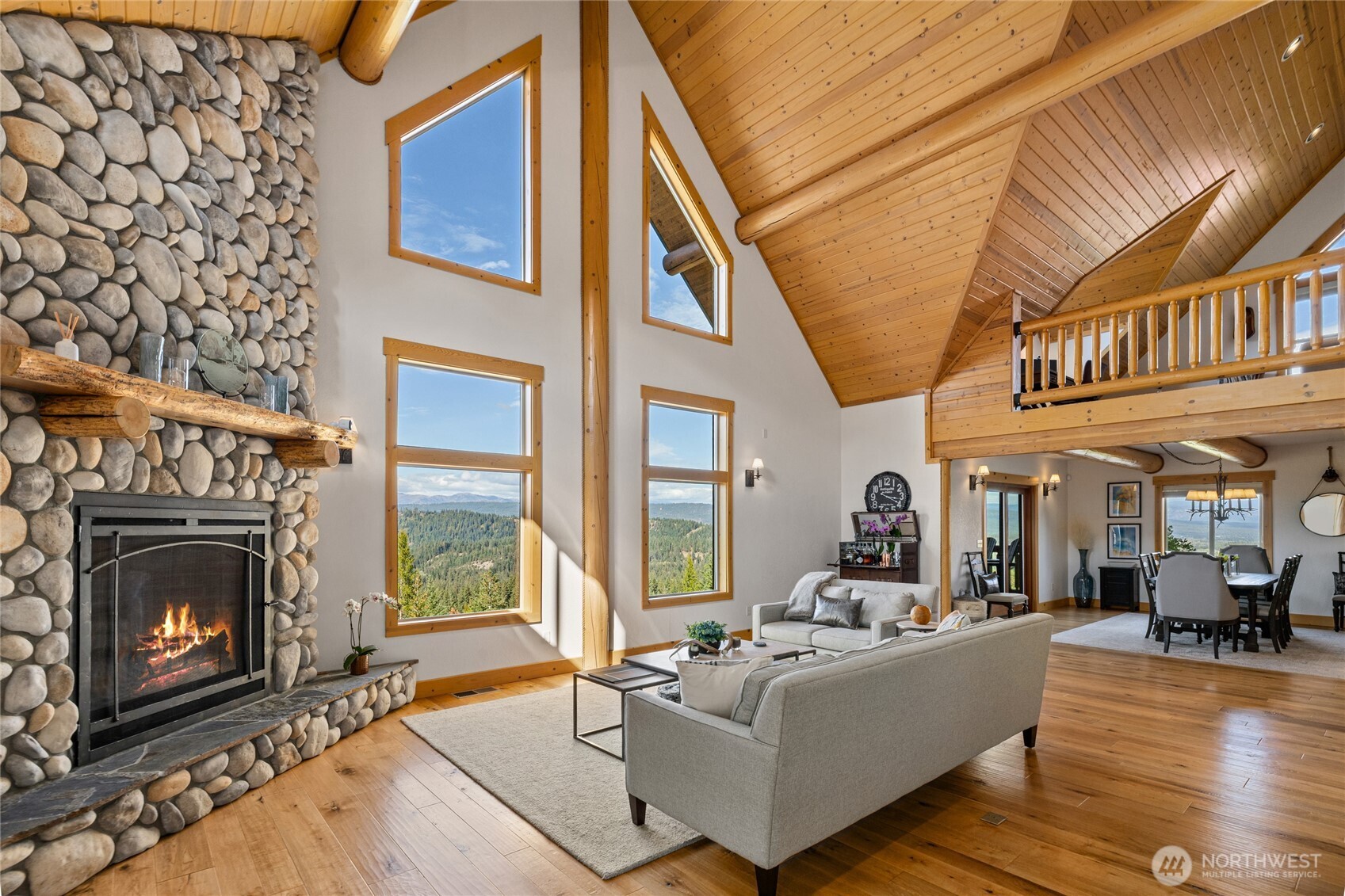 The open main level connects the great room and dining area, with expansive windows showcasing the surrounding mountain scenery.