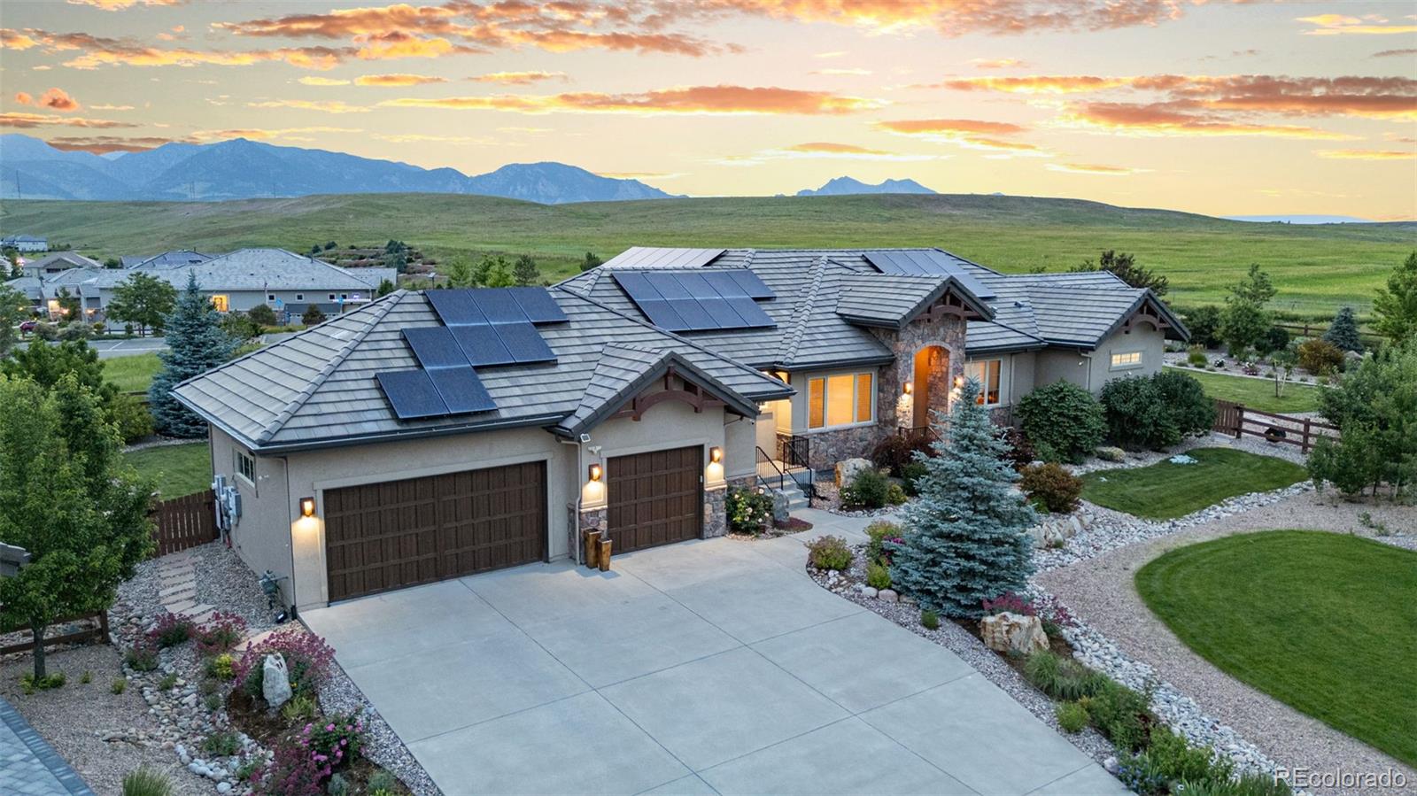 Experience refined living in this fully custom 2016-built home, designed to capture city and lake views from the front and protected mountain and wildlife refuge views from the back. This residence blends timeless luxury, thoughtful function, and a true connection to nature.

Inside, soaring 11-foot ceilings and rich alder wood accents create warmth and grandeur. The living room offers vaulted ceilings, custom built-ins, and a stone fireplace. Off the secondary entrance, a mudroom with pocket office, custom dog wash, and doggy door adds daily convenience. A striking ½ bath with carved stone sink makes a bold statement.

The chef’s kitchen impresses with a massive honed granite island, alder cabinetry, Miele refrigeration, dual Bosch dishwashers, and a Thermador 6-burner gas cooktop with Wolf induction range. A stone hearth with pot filler anchors the space, while a butler’s pantry with beverage fridge and ice maker enhances entertaining.

The primary suite is a private sanctuary with tray ceiling, garden and mountain views, and a fireplace with decorative stone surround. The spa bath features dual vanities, alder cabinetry, a frameless shower with triple heads and body sprays, a jacuzzi soaking tub with mountain views, and dual walk-in closets.

The finished basement offers oversized windows, a full wet bar with dishwasher, three bedrooms, two baths, and additional laundry—ideal for guests or multi-generational living.

Outdoors, a vaulted-ceiling covered patio boasts a smart-controlled stone waterfall, two-story stone fireplace, built-in grill, and beverage fridge. The landscaped grounds include mature fruit trees, berry bushes, flowers, and raised garden beds.
Additional highlights: 4-car tandem garage with EV charging, seller-owned solar with 2 Tesla power banks, central vac, Aqua Sauna water system, and built-in speakers. A rare blend of sustainability, craftsmanship, and luxury.