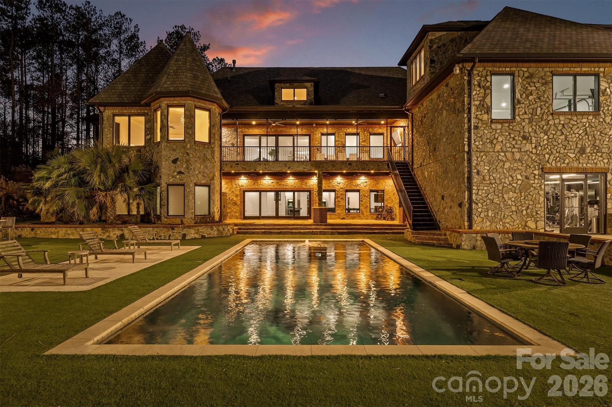 Welcome to the Crown Jewel of Lake Norman Living. Resort LivingTucked away in the prestigious Twinn Coves on Morrison community, this magnificent gated Modern Tuscan Estate sits on nearly 9 private acres just minutes from the sparkling shores of Lake Norman State Park. Custom-built with obsessive attention to detail, this 11,241 square foot masterpiece blends Old World elegance with modern luxury — and elevates the very definition of resort-style living.From the moment you arrive through the private gated entrance, it's clear this is no ordinary estate. Soaring ceilings, select marble tiling, and curated finishes set the tone throughout, while expansive entertaining spaces on every level ensure there's always room for the grandest of gatherings. The chef's kitchen is as functional as it is stunning, and the custom-designed wine cellar — crafted in a rich, old-world style — is a connoisseur's dream.Entertainment here isn't an afterthought — it's a lifestyle. Host cinematic nights in your private in-home movie theatre, challenge guests in the vintage arcade game room, get a fresh cut in your very own in-home barbershop, or wind down in the sophisticated wine room. For fitness enthusiasts, a fully equipped indoor gym keeps you at your best without ever leaving home.Step outside and enter your personal resort. A sparkling pool and expansive pool house with outdoor cooking area anchor the grounds, while a half football field, outdoor basketball court, custom mini golf course, and a playground set ensure fun for every age and every occasion. The lush, meticulously maintained acreage also features walking trails and room to roam — a rare combination of space and serenity.Security and peace of mind come standard, with a comprehensive whole-home security system featuring full-range camera coverage and a gated private entry keeping the estate fully protected.All of this, just moments from the waterfront dining, boating, and vibrant recreation of Lake Norman — and with easy access to I-77 for a seamless commute to Charlotte.This is more than a home. It's a destination. Schedule your private showing today.