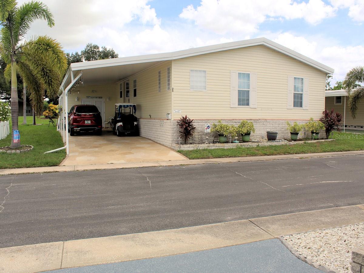 Are you looking for A Forever Home? This 2007 Jacobsen manufactured home in Palm Hill Mobile Home Park offers 1,962 heated and cooled square feet is well worth considering. It has two bedrooms and a generous size den.   The property is ideally situated on Palm Hill’s golf course on the ninth tee. One monthly maintenance fee of $554 covers a lot-water, sewer, trash, recycle, lawn care, cable and internet. No one stays a stranger for long in this outstanding five-star,55+park. From pools, jacuzzies, tennis, pickleball, golf, shuffleboard, to clubhouse activities it is easy to make friends. This turnkey home has had only one owner. All walls are finished with drywall and ceilings are vaulted. It has been beautifully maintained and updated and is being sold mostly furnished.  The kitchen updated in 2022 has a striking roomy island with cooktop and sitting space.  Quartz countertops sparkle throughout the kitchen. Abundant white cabinets and cupboards offer excellent storage.  White appliances—wall oven, microwave, refrigerator with French doors, and dishwasher complement the décor.  Two windows over the sink present a pleasant view outside. The kitchen flows naturally to the dining space. Behind the table there is a built-in display space with storage drawers below.  The generous size living room lies immediately behind the dining area.  Note: The kitchen, dining, and living room are all part of an open concept design.  Windows on the far side bring light inside. Both the dining and living area have cut glass windows and open to a generous size Florida room which looks directly out to the golf course. Tall windows make it easy to watch golfers passing by. Sliding doors at one end lead outside to a cozy patio overlooking the golf course.  Both bedrooms are located at the front of the house.   The generous size primary has a walk-in closet.  The ensuite bath has a good size closet for towel storage, an updated vanity and a large shower with bench and two shower heads (one on each side.) The guest bedroom with wall closet is situated across from the hall bath with tub and shower attachment.  Both baths feature updated toilets and sinks.  French doors off the hallway highlight the den or office behind them.   No need to go outside for laundry chores.  The spacious interior laundry room is equipped with a brand-new washer and dryer, as well as a laundry sink with storage cabinet below, and a pantry closet. Other noteworthy details: laminate floors, tile in kitchen, baths, and laundry; ceiling fans throughout; skylights in kitchen, primary bedroom and ensuite; windows with marble sashes; and pleasant wall color. The soft yellow exterior, thermal pane windows, white shutters, extended carport, and designer driveway create a welcoming appearance and suggest appealing features inside.   At the end of the carport doors lead into an additional storage area.  The home has a new roof in 2025.  A share of $35,000 is included in the list price of this lovingly cared for golf course home.  Please call for an appointment as this is owner occupied.