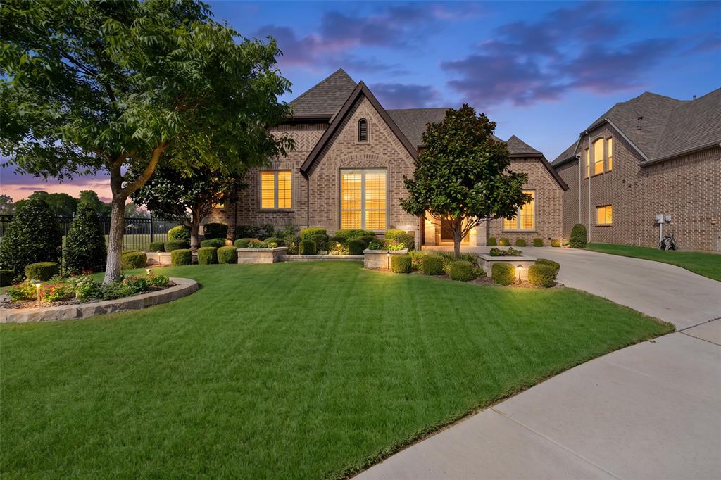 Check out this stunning K. Hovnanian built home that shows like a model and reflects exceptional pride of ownership on a beautiful oversized lot in the coveted gated community of Heron Pond, featuring two ponds, scenic walking trails, and Keller ISD. The beautifully manicured front yard features mature magnolia trees, stone-bordered flower beds, decorative planters, and added privacy with green space and no neighbors to the left or behind. Inside, genuine nail-down wood floors, elegant archways, soaring ceilings, open dining, and private office with French doors create a refined first impression. The large living room with gas fireplace flows into the beautifully appointed kitchen featuring quartz countertops, large island with breakfast bar and sink, stainless appliances, gas cooktop, double ovens, and textured subway tile backsplash with decorative mosaic accent. Plantation shutters throughout, updated lighting, caged cube lantern pendants, warm grey and white palette, and abundant windows create a sophisticated, inviting atmosphere. The spacious primary suite offers an updated bath with navy accent walls, oversized walk-in shower, large corner tub, and impressive walk-in closet with custom built-ins and full-length dressing mirror. Custom closets throughout provide exceptional organization, while generously sized secondary bedrooms feature large walk-in closets and additional speakers. Bathrooms offer granite countertops and tasteful finishes, plus a completely renovated half bath. The garage entry includes a custom storage bench and coat rack, while the large laundry room offers a mud sink and abundant storage. The garage features custom storage, epoxy flooring, and new attic ladder. Additional speakers are installed in bedrooms, entryway, and back porch. Enjoy the private outdoor retreat with extended covered patio and hanging drapes, creating an inviting setting for relaxing or entertaining. Jellyfish permanent lighting surrounds the home. Welcome Home!