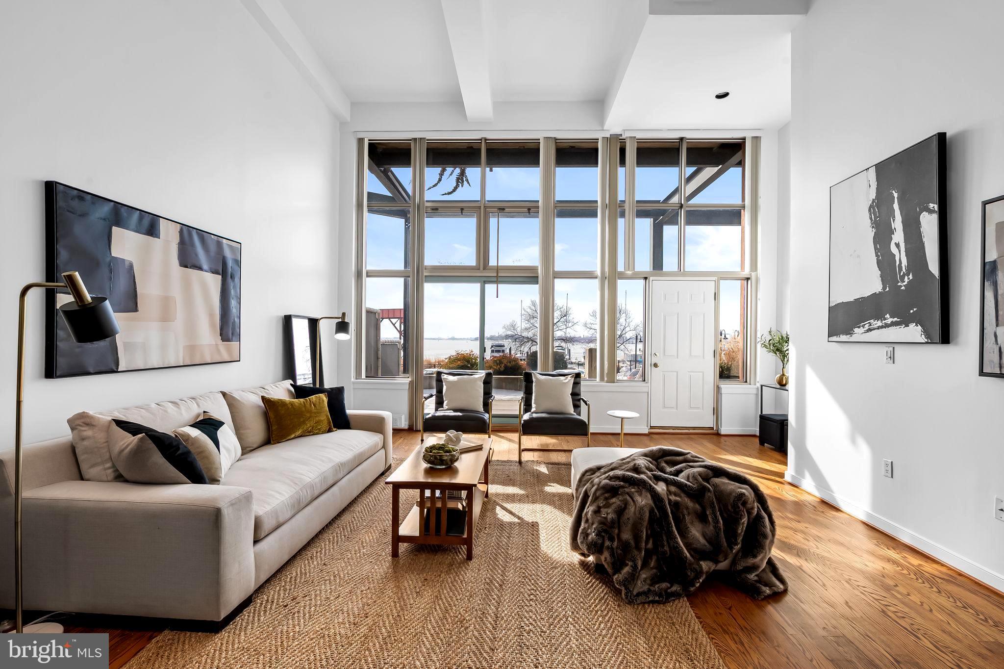 Rarely available Canton Cove waterfront loft townhome. This exquisite 3 Br/2.5 Ba residence boasts 1,823 sq. ft. of premier urban living space.  Upon entering the home from the waterside on the main level, an amazing sense of style and functionality is evident in the dramatic living and dining spaces enhanced with 18’ ceilings, dramatic walls of windows, beautiful water views, and handsome hardwood flooring.  The newly remodeled kitchen is a chef’s dream with stainless steel appliances, gas cooking, granite countertops and stylish cabinetry. The en-suite Primary Bedroom and Bath adjoin the living areas.  The stunning Bedroom features a floor to ceiling wall of windows with water views and an additional terrace access door, an 18’ ceiling, and a spacious walk-in closet.  The Bathroom has a double sink vanity, stone countertops, walk-in shower, storage area, and stone flooring. At the rear of the home, there is a Half Bath, a laundry area with stacked washer/dryer, and convenient access to the garage parking space #25 located directly in front of the back doorway.  The mezzanine level features a lovely second Bedroom with built-in cabinetry and a large walk-in closet, a third Bedroom with a utility area, and a second Full Bathroom. Both bedrooms have overlooks to the lower level. The flooring throughout the mezzanine is gorgeous plank vinyl. A highlight of this amazing residence is the expansive 31' X 11' front terrace with water views and access within steps to the second exterior parking space #27. The private terrace is perfect for casual dining, relaxation, or watching boats and fireworks.  A large storage space conveys.  Gas, water, and sewer are included in the monthly condo fee.  24-hour front desk coverage is provided along with security monitoring. Residents and their guests can also enjoy and relax on the building's fabulous sizeable observation terrace with spectacular city and water views, the Baltimore Harbor, Ft. McHenry, and fireworks.  A library/conference room is provided for residents.  Canton Cove is located within walking distance to “The Square”, Canton Crossing, restaurants, bars, supermarkets, shopping, and parks.  Within proximity are Downtown Baltimore, Patterson Park, recreation and fitness centers, Harbor East, Fells Point, Brewer’s Hill, Johns Hopkins and U of M campuses, institutions, and major highways.