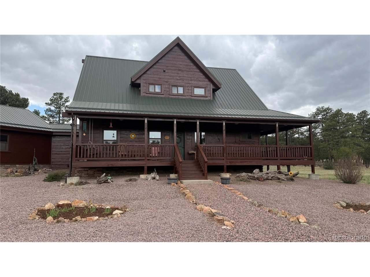 Some properties sell you a lifestyle. This one already lives it. Thirty-five acres in the Colorado foothills, wrapped in Ponderosa pine, pinion, juniper, and scrub oak, with three open meadows, rock outcroppings rising from the back of the land, and Wet Mountain views stretching farther than you can take in at once. On a clear morning out here, and there are plenty of them, it is hard to imagine being anywhere else. This is high country land with real character, and it shows in every single direction you look. This two-story home with finished basement offers more than 2,100 square feet of living space above grade. The main floor holds a primary suite with private bath, a dedicated office, a great room with eating area, a kitchen with quartz counters and a gas range, and a mudroom with laundry that connects to an oversized two-car garage. Upstairs, two bedrooms and an open loft share a full bath with walk-in shower. The basement is nearly finished and includes a dedicated food storage room, a detail that tells you something about how thoughtfully this home was designed and built for the long haul. Off-grid does not mean roughing it here. A 5,400-watt solar array with LiFePO4 battery backup, a solar-powered deep well feeding a large buried cistern, a 14,000-watt Kohler generator, and a 1,600-gallon permitted water collection system give you genuine four-season confidence. A wood stove crackles to life on the coldest mornings while a gas furnace and an owned 1,000-gallon propane tank back everything up. Grid connection is right nearby if you ever decide you want it. Step outside to a large covered front porch, a deck off the great room, a back pavilion perfect for summer dining, a 20x13 foot greenhouse, a fenced garden area, and a personal observatory built for Colorado's famously dark and star-filled skies. Contact us today to be the very first in line when this one hits the market.