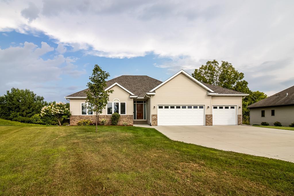 Beautiful 4-bed, 3-bath rambler just steps from Madison Lake! This well-maintained home features a large foyer that leads to an open-concept living room offering large windows for plenty of natural light and a cozy gas fireplace. The combined dining room and kitchen offers stainless steel appliances, breakfast bar seating, and access to the deck with superb lake views for relaxing with your morning cup of coffee and watching the sunrise. The main floor includes an office (optional 4th bedroom), full guest bath recently updated paint, jet tub, fixtures, toilet, lighting, and a primary suite with private ¾ ensuite bath that has been recently renovated to include heated tile floor, new vanity, fixtures, lighting, large walk-in tiled shower with U by Moen Smart Shower that connects to Alexa, Hey Google and Apple HomeKit for a customizable showering experience. The walkout basement includes a family room with pool table that stays with the home, bar with mini fridge and surround system throughout this level. The lower level patio doors lead to a concrete patio with lake views and fenced area.  A media room (or optional bedroom), craft room/office, ¾ bath with walk-in tiled shower, third bedroom, and oversized storage room complete the lower level. Enjoy a spacious yard complete with sprinkler system, large composite deck, backyard patio, and finished 3-stall garage with overhead heater. Additional updates include: new carpet on main level (August 2025) , new water softener (2025), and sub-panel to support the dedicated EV charging station for convenient electric vehicle charging at home (2024) new blinds in living/dining/family room (2022).