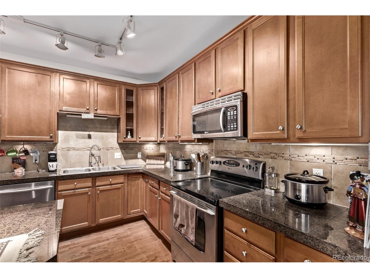 5.25% assumable rate! Amazing opportunity to live in a fantastic community with pool & lush parks! Welcome to Stonegate, a peaceful community with a great location where you'll find this wonderful 2 bedroom condo featuring a bright & spacious open floor with seamless living & dining areas that promote a greater traffic flow for easy entertaining. Discover tall ceilings, soft grey palette, and plush carpet with laminated floor in all the right places. The bright living room has a fireplace & access to the balcony, providing warmth & comfort for relaxation. At the dining area, you'll find a built-in desk for convenience. The beautiful kitchen showcases track lighting, a plethora of wood cabinetry, tile backsplash, granite tile countertops, stainless steel appliances, and an island with a breakfast bar. The primary bedroom hosts a large bathroom with an oversized double vanity & a step-in shower with a built-in bench, plus a bountiful walk-in closet. You'll love its easy access to multiple Hwys and close proximity to restaurants, shops, and schools. Don't forget to check out the amenities like the pool only a 2 minute walk down the sidewalk!