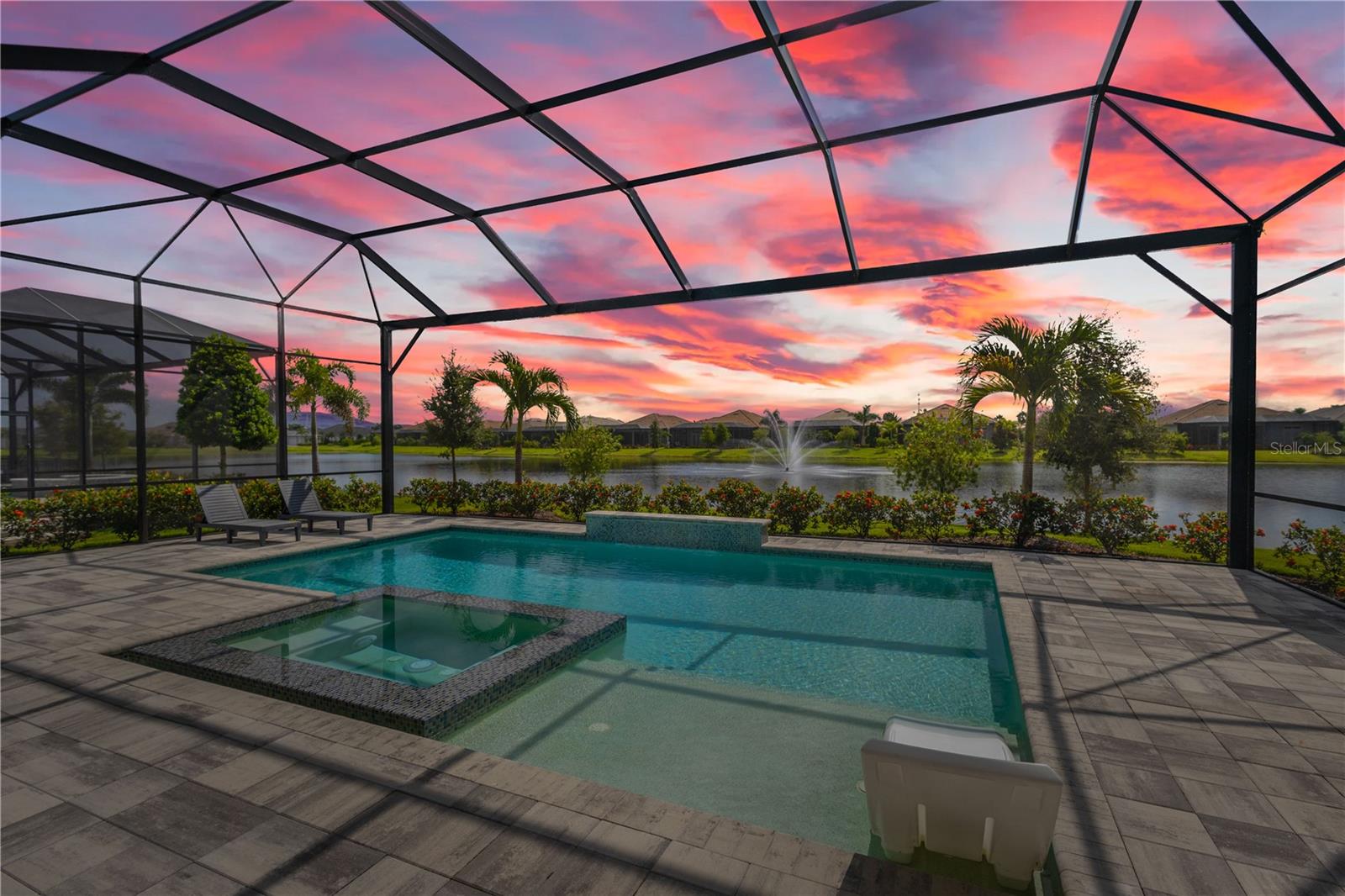 Nestled behind the gates of The Lake Club, this barely-lived-in 2023 built lakefront home is the pinnacle of luxury Florida living. Featuring three bedrooms, three-and-a-half bathrooms and a dedicated home office, this contemporary home was designed with function and beauty in mind. Over 2,600 square feet feel even more expansive with soaring ceilings, crown molding and architectural tray ceilings accentuating nearly every room.  The open living space is anchored by the Chef’s kitchen including; Custom Shaker-style cabinetry, oversized quartz island with bar seating for three and built-in, top-of-the-line stainless steel appliances.  Seamless indoor-outdoor living is achieved with pocketing, impact-rated sliding doors connecting to an additional 600 square feet of covered lanai and the extended pool area beyond. Encapsulating true Florida living, a custom pool features a sunken, 360-degree edge spa, sun shelf and waterfall feature.  After a day in the sun, retreat to an owner’s suite designed for relaxation with freestanding tub, separate walk-in shower, dual, split vanities and two customized walk-in closets. A spacious three-car garage with additional custom storage and epoxy floors provides all the room you need for your toys.  The Lake Club redefines luxury living in Lakewood Ranch, presenting residents a 22,000 square foot Grande Clubhouse with a full-service restaurant and bar, two resort-style pools, fully equipped fitness center, spa services and concierge amenities. Residents also have access to several tennis and pickle ball courts, basketball court, two dog parks and social events curated by a dedicated Lifestyle Director.  Within America’s top-rated multigenerational community, you’re just minutes from upscale dining and shopping at Waterside Place and University Town Center, world-renowned golf and convenient to Downtown Sarasota, Gulf Beaches and cultural venues like the Van Wezel Performing Arts Hall.