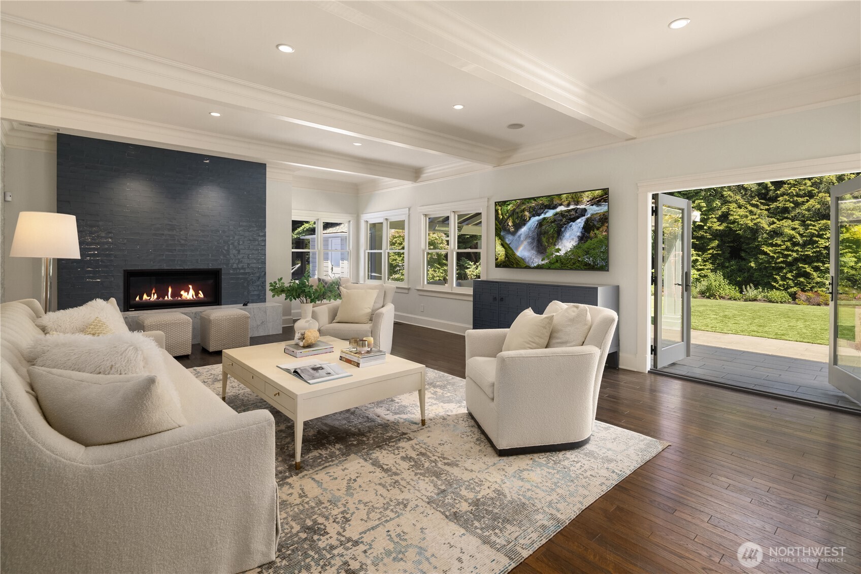 Living room anchored by a sleek linear fireplace and French doors to the patio