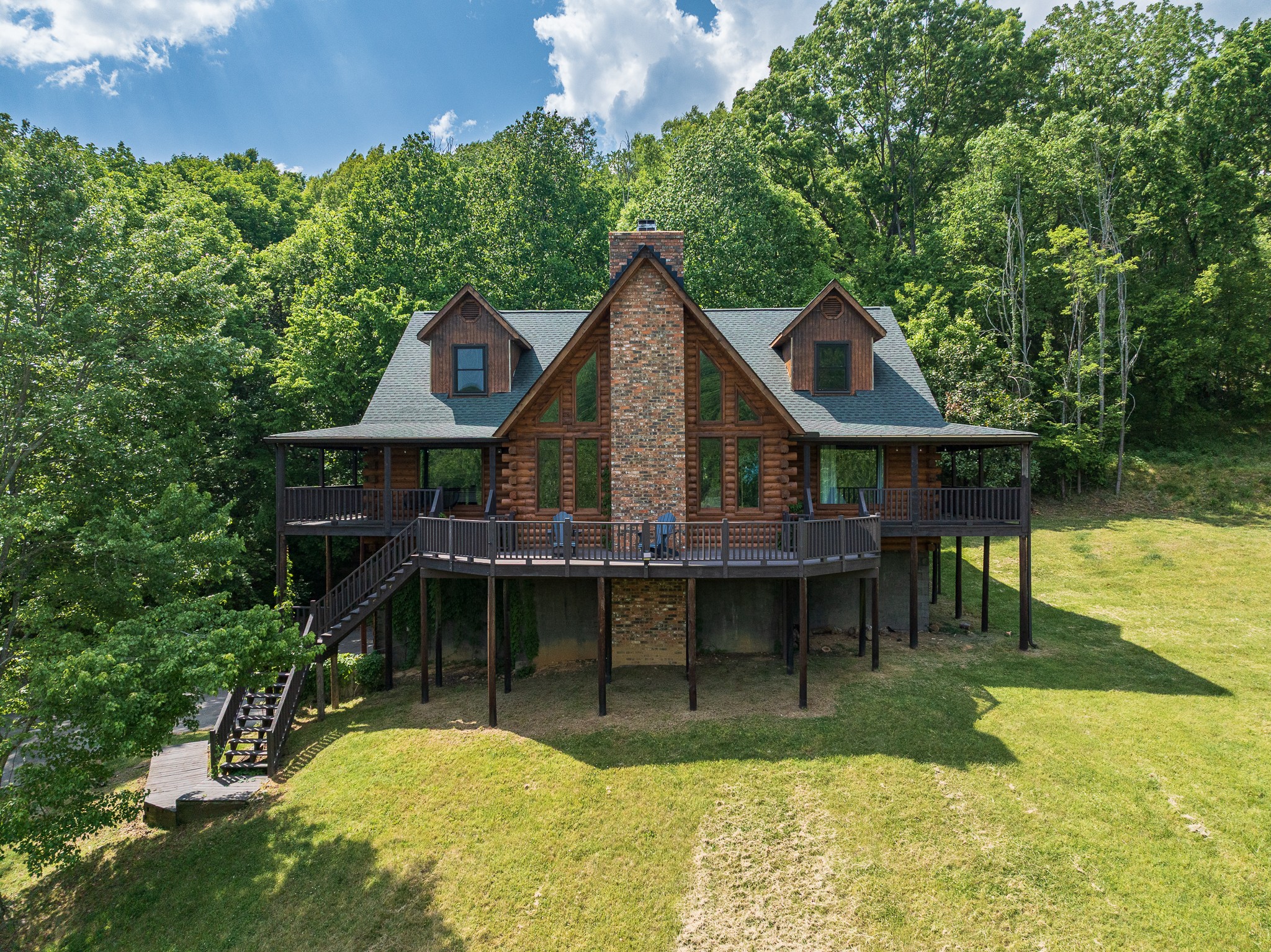 New price, fresh spring photos, and a renewed look at one of Nolensville’s most unique acreage opportunities. Set on five peaceful acres in coveted Warren Hollow, this warm log-built retreat offers the kind of privacy, views, and flexibility that are increasingly hard to find—especially with no HOA. The new exterior photos show the property at its best: lush green surroundings, mature trees, open lawn space, big-sky views, and covered porches wrapping all four sides of the home.Inside, the vaulted Great Room delivers classic cabin character with soaring ceilings, abundant natural light, and a comfortable gathering space made for relaxing, entertaining, or hosting weekend guests. The main level features a true primary suite plus a flexible second room that works well as a bedroom, office, den, or hobby space. Upstairs, a lofted bonus area overlooks the Great Room and connects to two private bedrooms, each with its own full bath and walk-in closet.The unfinished basement adds roughly 2,000 square feet of expansion potential—ideal for a media room, guest suite, game room, fitness space, studio, workshop, or additional storage. Septic is approved for 4 bedrooms.This property also has excellent short-term rental and Airbnb-style potential. The current owner has rented it frequently, and the setting naturally fits what guests look for: privacy, acreage, porch space, cabin charm, scenic surroundings, and easy access to Nolensville, Franklin, Brentwood, Cool Springs, and Nashville. Buyer to verify all STR eligibility, permitting, and regulations.Thoughtful improvements include a fresh asphalt driveway, full home log restoration/preservation, new back-entry stairs, selective tree and land clearing, roof and HVAC replacement within the past decade, and a newer water heater.