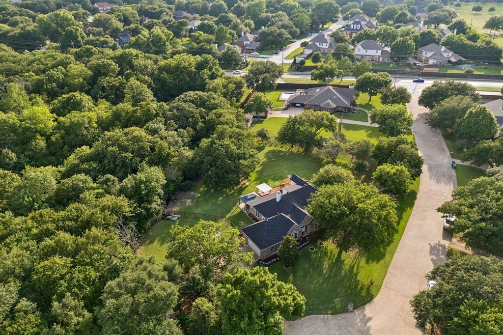 Welcome to holly lane where you will find a rare nearly 1 acre lot in the heart of DFW. Recently renovated and tucked away on a quiet and private cul de sac, 1092 Holly Lane in Lewisville offers a timeless blend of character, space, and outdoor living in a beautifully treed setting. This home spans 3,021 square feet and welcomes you with wood look tile flooring and a spacious living room centered around a cozy fireplace with a beautiful beamed ceiling, flowing seamlessly into the dining area and a well appointed kitchen featuring granite countertops, an induction cooktop, and a bright breakfast area with direct access to the backyard. The primary suite boasts a fully redesigned ensuite bath with a double shower featuring rain showerheads, dual vanities, and separate his and hers water closets two secondary bedrooms and a full bath complete the main level.A circular staircase leads upstairs to a versatile game room, exercise room and office area with access to a walk out balcony, adding even more functional space. Step outside to experience a backyard designed for entertaining and relaxation, featuring a pergola, hot tub, and plenty of room to gather under mature trees. Additional highlights include a workshop with electrical power, RV parking with hookups, and ample space for hobbies or storage. Located in the heart of Lewisville, this home offers convenient access to major highways, shopping, dining, and entertainment, as well as nearby parks and Lewisville Lake for outdoor recreation. This property combines comfort, charm, and lifestyle in a prime location.