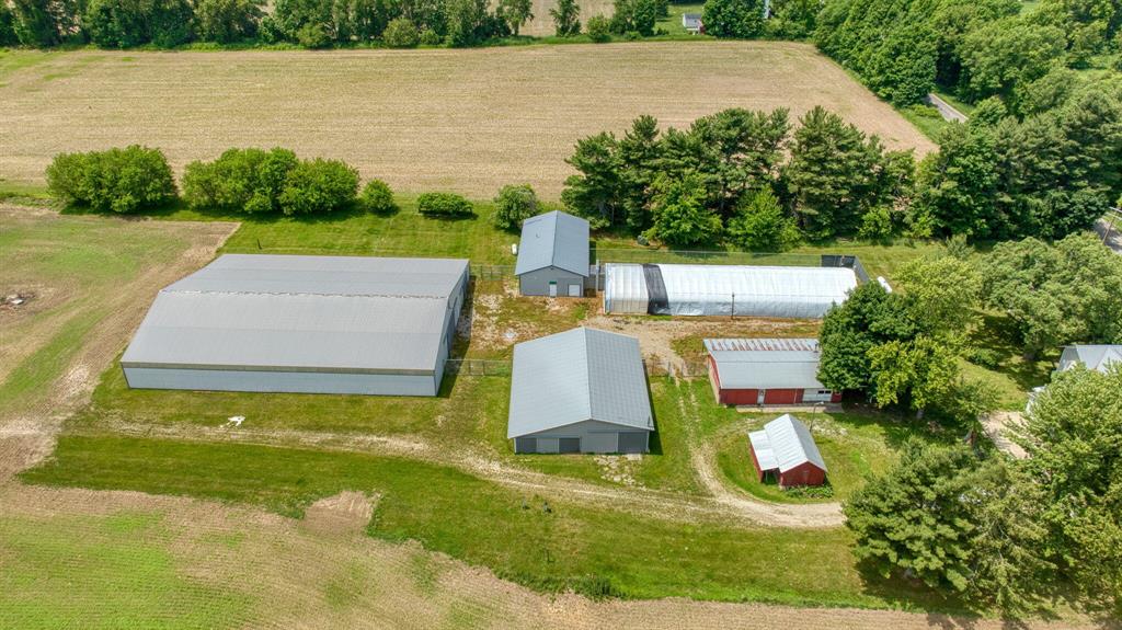Open House: Saturday June 28, 11 - 1! Discover an incredible opportunity at 15379 Howard Road in Hanover, where a completely remodeled 5-bedroom, 2-bath farmhouse sits on over 15 scenic acres. This charming home boasts fresh paint, new carpet, and updated fixtures throughout, including beautifully refreshed bathrooms. The main level offers a comfortable layout with a spacious kitchen, inviting dining area, cozy living room, and convenient laundry room. You'll also find a large bedroom and a versatile smaller bedroom on the main floor, perfect for a home office, den, or hobby space. Upstairs, three additional bedrooms and a second full bathroom provide ample living space. Relax and enjoy the tranquil surroundings from the pleasant front porch, ideal for cool summer mornings or crisp fallevenings. This expansive farm is a haven for entrepreneurs and hobbyists alike, featuring an impressive array of outbuildings. A substantial 50x22 three-car garage includes convenient lean-tos on the side and back for additional storage. For the green thumb, a 120x35 greenhouse is equipped with robust 400 amp, 208-volt electric service. This greenhouse seamlessly connects to a 65x32 office/lab space complete with a half bath, offering easy conversion into an efficiency apartment - perfect for a caretaker or additional income. Equine enthusiasts will be delighted by the 60x50 barn featuring six box stalls, electric and frost-free hydrants. The crowning jewel for horse lovers is the massive 128x105 ft pole barn, housing an impressive 128x80 ft indoor riding arena with 11 box stalls down the side and a dedicated tack room. This pole barn also benefits from electric service and frost-free hydrants. Imagine the possibilities: run two businesses simultaneously, launch your dream equine operation, or cultivate a thriving plant business. This property is also perfectly suited for a hobby farm, allowing you to enjoy your own horses and ride year-round, or explore the expansive 15+ acres on horseback in the fall. The peaceful setting and con