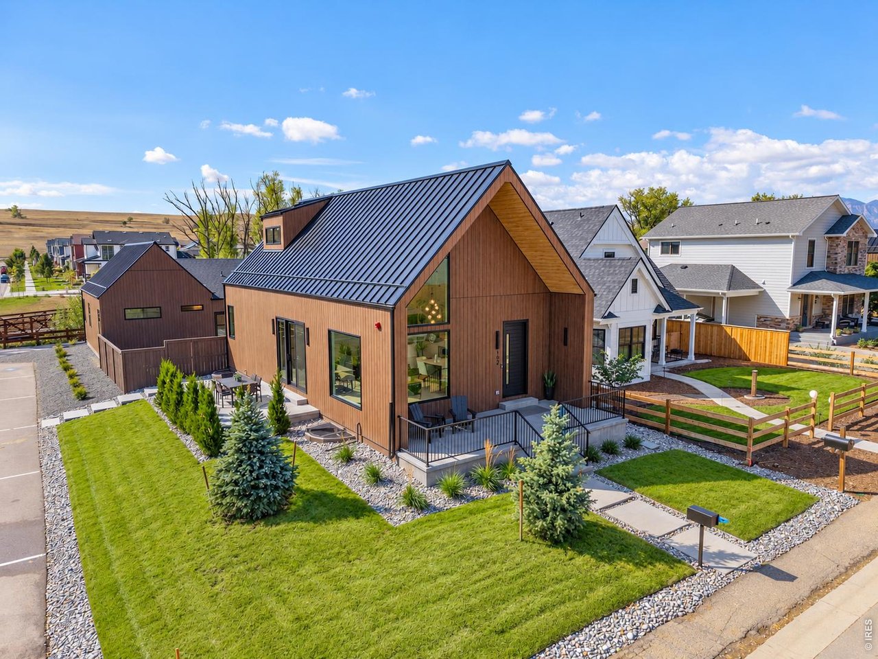 Designed to stand apart, this architecturally distinctive, modern Scandinavian home in Original Town Superior features a separate alley-accessed ADU and sits on a spacious corner lot just steps from historic Grasso Park and Coal Creek. Soaring ceilings create an impressive sense of openness in the main living area, while the kitchen and oversized island anchor the space. A seamless built-in refrigerator, 6-burner gas range, and accent cabinet lighting bring both function and refined modern style to the kitchen. Just off the living area, a large patio extends outdoors to the professionally landscaped yard, while a raised front porch with sleek metal railings and a standing-seam metal roof complement the home's striking modern exterior. The main-level primary suite at the back of the home offers a walk-in closet and private bath, while the expansive upper loft is perched above the living area. Rounding out nearly 2500 sqft in the main home, the finished basement adds a generous recreation room, 2nd bedroom, full bath, laundry with washer/dryer, and plenty of storage. At the rear of the property, a separate 665-sqft ADU adjoins the extended 2-car garage, both with convenient alley access. The ADU offers its own kitchen, living room, private bedroom, 3/4 bathroom, and laundry closet with washer/dryer. It features views of the open-space trail that crosses a scenic bridge over Coal Creek and winds through the park, connecting to Boulder County's extensive Coal Creek Trail network. Original Town also offers convenient access to Founders Park, Target, Whole Foods, and Costco, with the added benefit of no HOA dues or additional metro district taxes.