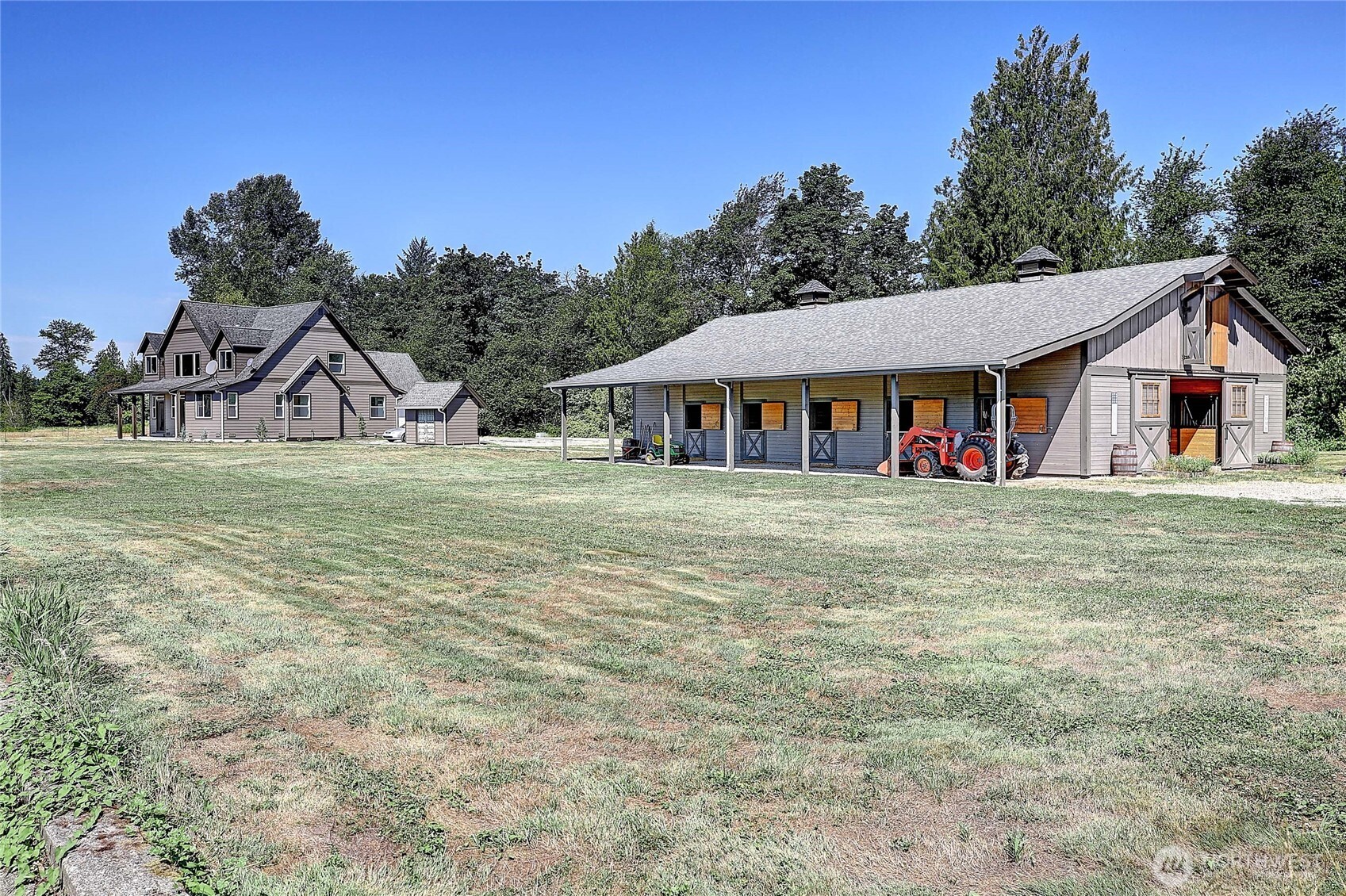 HORSE PROPERTY - Welcome to this beautiful 2,474 sq. ft. home, on 24.68 acres! Built in 2012, featuring 3 bedrooms, 2.5 baths, 22-foot ceilings, hardwood floors, maple kitchen cabinets, farm sink, quartz counter tops, stainless steel appliances, spacious mudroom + wired for a whole-house generator. GORGEOUS 10-stall custom barn w/ heated wash rack, tack room, and 500-bale hay loft. Additional amenities include a round pen area, 100x60 outdoor arena, outbuildings, lush fully fenced pastures, & two RV hookups. The facility can generate income from horse boarding and RV spots, making it both a dream lifestyle property and a smart investment. Enjoy nearby access to White Horse Centennial/Pilchuck Trail, and fishing at Stillaguamish River!