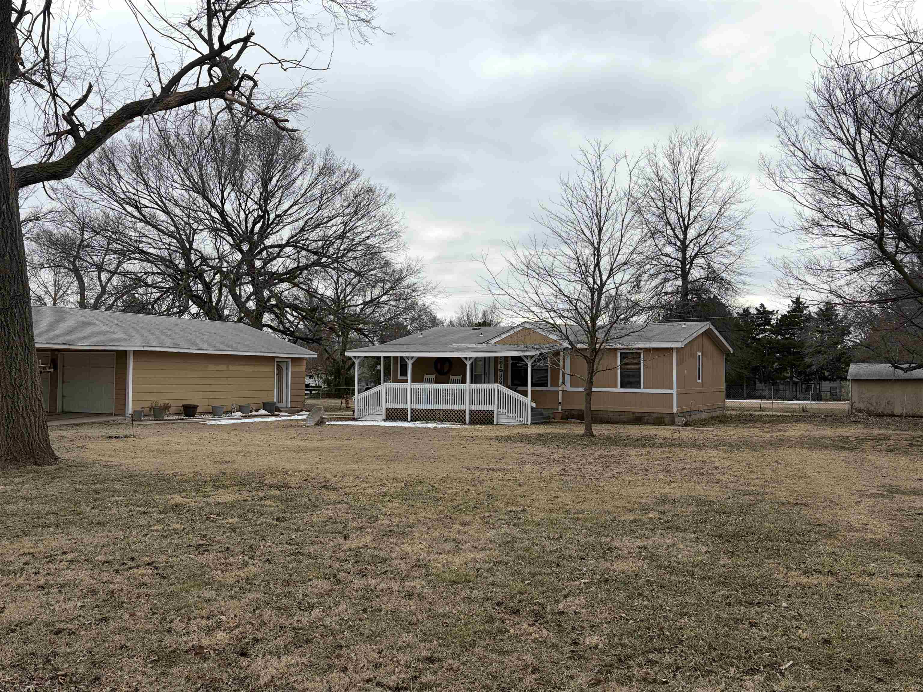 This charming 3-bedroom, 2-bath home offers 1,120 sq. ft. of comfortable living space, nestled on a spacious 1 ACRE LOT with multiple storage sheds. The inviting covered front porch creates a warm welcome, perfect for relaxing. At the back, a small deck and a patio area provide ideal spots for outdoor lounging. The property includes a 2-car detached 33x24 oversized garage featuring a workshop area.   Additionally, a separate 30x20 metal shop comes equipped with its own breaker box and 50-amp service, ideal for more intensive work or equipment needs. Complementing these structures are (3) 12x8 sheds, providing generous storage options for tools, lawn equipment, or seasonal items. Property is fenced on the east and west sides.