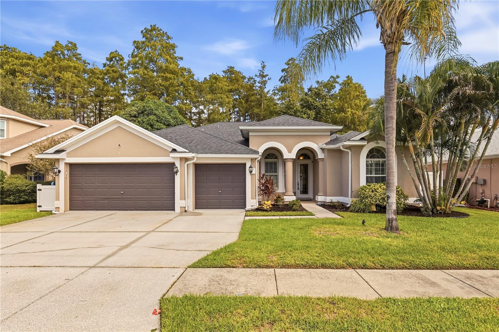 Welcome to this beautifully appointed four bedroom, three bathroom home in desirable Tarpon Springs, offering an ideal combination of thoughtful design, spacious living and beautiful surroundings. The highly desirable split floor plan provides privacy and flexibility, with generously sized bedrooms and living spaces designed for everyday comfort and entertaining. Soaring ceilings, bullnose corners and built in plant shelving add architectural character throughout, while tile flooring provides a clean, cohesive look and easy maintenance.The kitchen is a standout, featuring staggered cabinetry with glass inlays, decorative molding and an elegant Italian glass backsplash. The spacious primary suite offers a peaceful retreat with a view of the pool, along with dual vanities, a garden tub, private water closet and two closets for plenty of storage.Additional highlights include a brand new roof, gutters, spacious three car garage with epoxy flooring and built in storage, convenient interior laundry room with mud sink. Step outside to enjoy the backyard with a serene conservation view, creating a private backdrop for relaxing or entertaining. With its spacious layout, quality features and desirable Tarpon Springs location, this home offers the space and setting you've been looking for. Come tour it today!