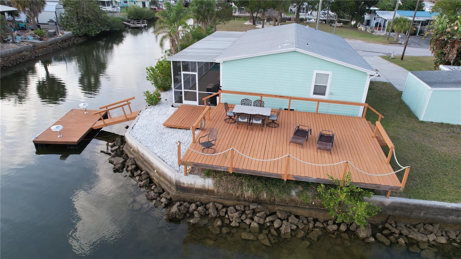 ESCAPE to your own private sanctuary with this charming, 3 bed, 2 bath, oversized corner waterfront lot. This home boasts 130 feet of seawalll (partial replacement in 2022) with quick and easy access straight out to the Gulf of America! Fully remodeled in 2025 with all new molding, doors, blinds and water resistant flooring throughout. Foam insulation, new split AC units, lower cabinets and 4 foot PVC walls throughout home for easy removal should another water intrusion event occur. Both electrical panels are upgraded and electrical outlets brought up to current code. There is an abundance amount of space to entertain guests on the 21 X 27 deck overlooking the water while friends fish from  the new 8 X 16 floating dock or relax in the huge fire pit area.
