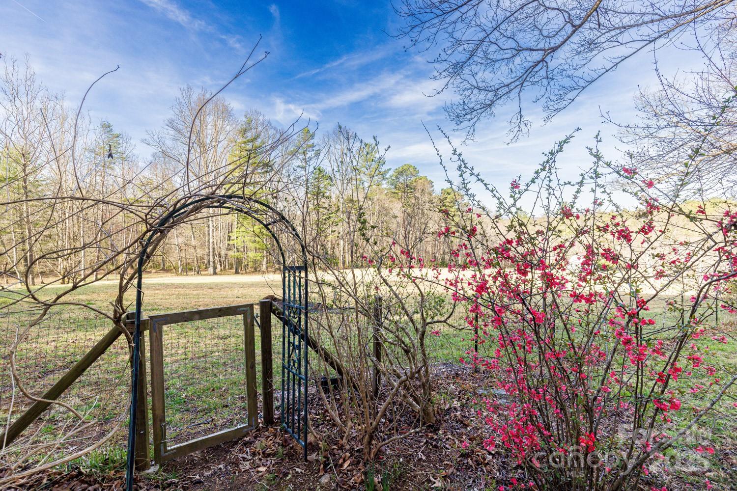 A true paradise for horse and nature lovers! This serene 9.14-acre property offers privacy, peace, and endless possibilities. Perfect for horses, livestock, farming, gardening, a flower farm—or simply a private retreat. The cozy living room, originally an 1800s chestnut oak cabin, features a woodstove and combines rustic charm with modern comfort. It opens into a spacious eat-in kitchen, ideal for gatherings. A bright and inviting sunroom overlooks wildflower gardens and a soothing waterfall. Upstairs, you’ll find a full bath, a primary bedroom, and three additional bedrooms. Unique architectural touches include recycled Douglas fir beams. Enjoy outdoor living on the expansive front porch and wrap-around deck, or relax in the fully fenced yard—perfect for pets. A registered Monarch Waystation and part of the Butterfly Highway, this home is a haven for pollinators and nature watchers alike. Just 20 minutes from Asheville and close to local breweries, hiking trails, and more.