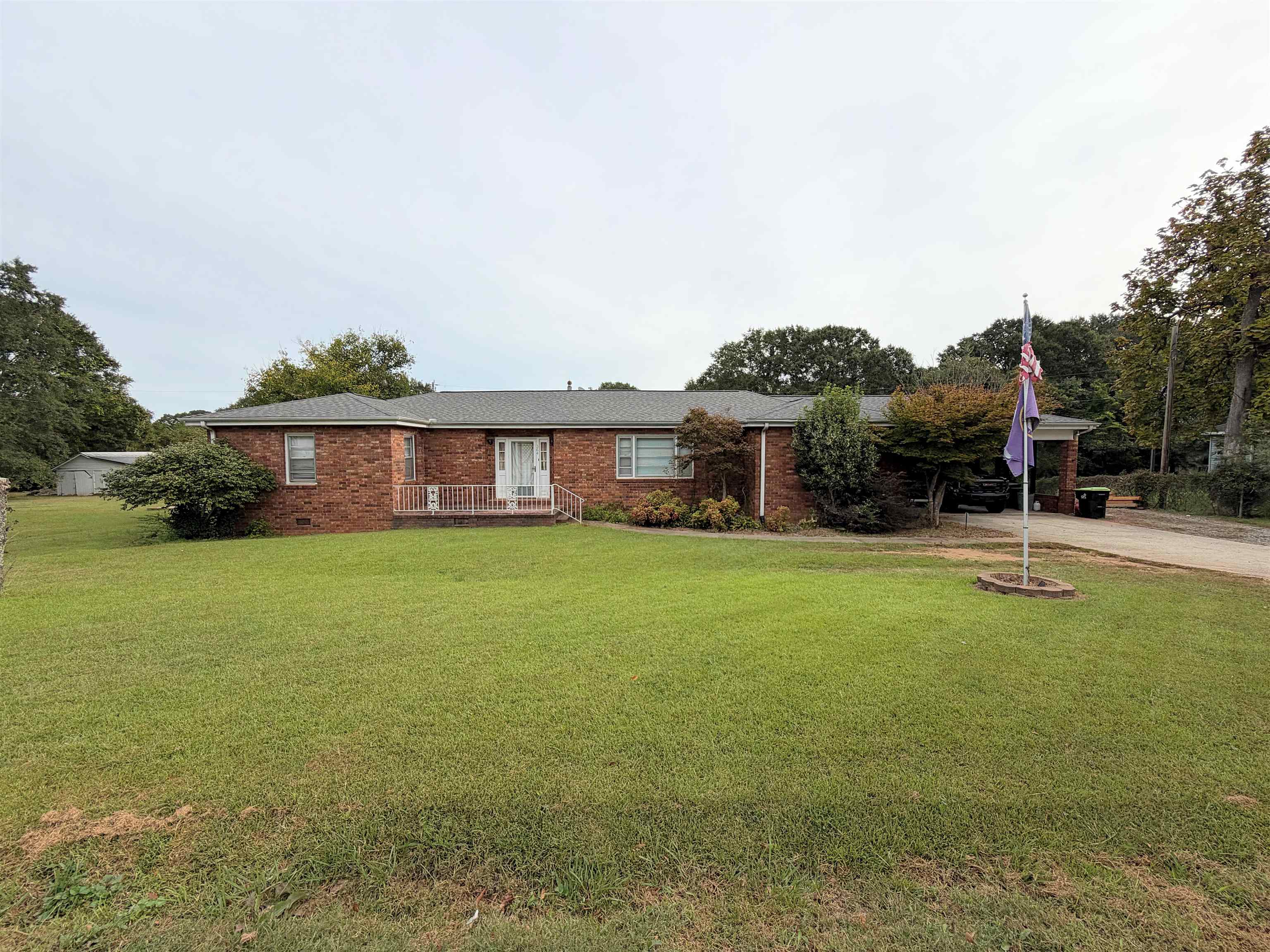 Classic brick ranch charm, room to spread out, and endless possibilities—all on a level 1-acre lot with no HOA! Located within the charming town of Duncan, this 2/3-bedroom, 2-bath home offers over 2,100 heated square feet of comfortable, single-level living. 2 traditional bedrooms plus 2 spacious flex rooms. A classic ranch layout, hardwood and tile floors, and a fireplace with gas logs create a welcoming setting. The owner’s suite includes a walk-in closet and full bath, with laundry!  Ready for cosmetic updates, this home offers great bones, abundant character, and an opportunity to make it your own. Whether you need space for a busy household, enjoy hosting guests, or want the ease of one-level living without sacrificing room, there’s plenty of flexibility here. Bring your vision and refresh it at your own pace.  A huge backyard featuring two separate fenced areas—offering options for pets, play, or gardening. A 2-car carport and storage outbuilding add practicality. Recent improvements include a new roof in 2025 and a heat pump in 2024.  Just minutes from quaint downtown Lyman and nearby Greer, with convenient access to both Greenville and Spartanburg, this property combines small-town appeal with an accessible Upstate location. Zoned for Tyger River Elementary, Beech Springs Middle, and James F. Byrnes High. Space, charm, and opportunity await!